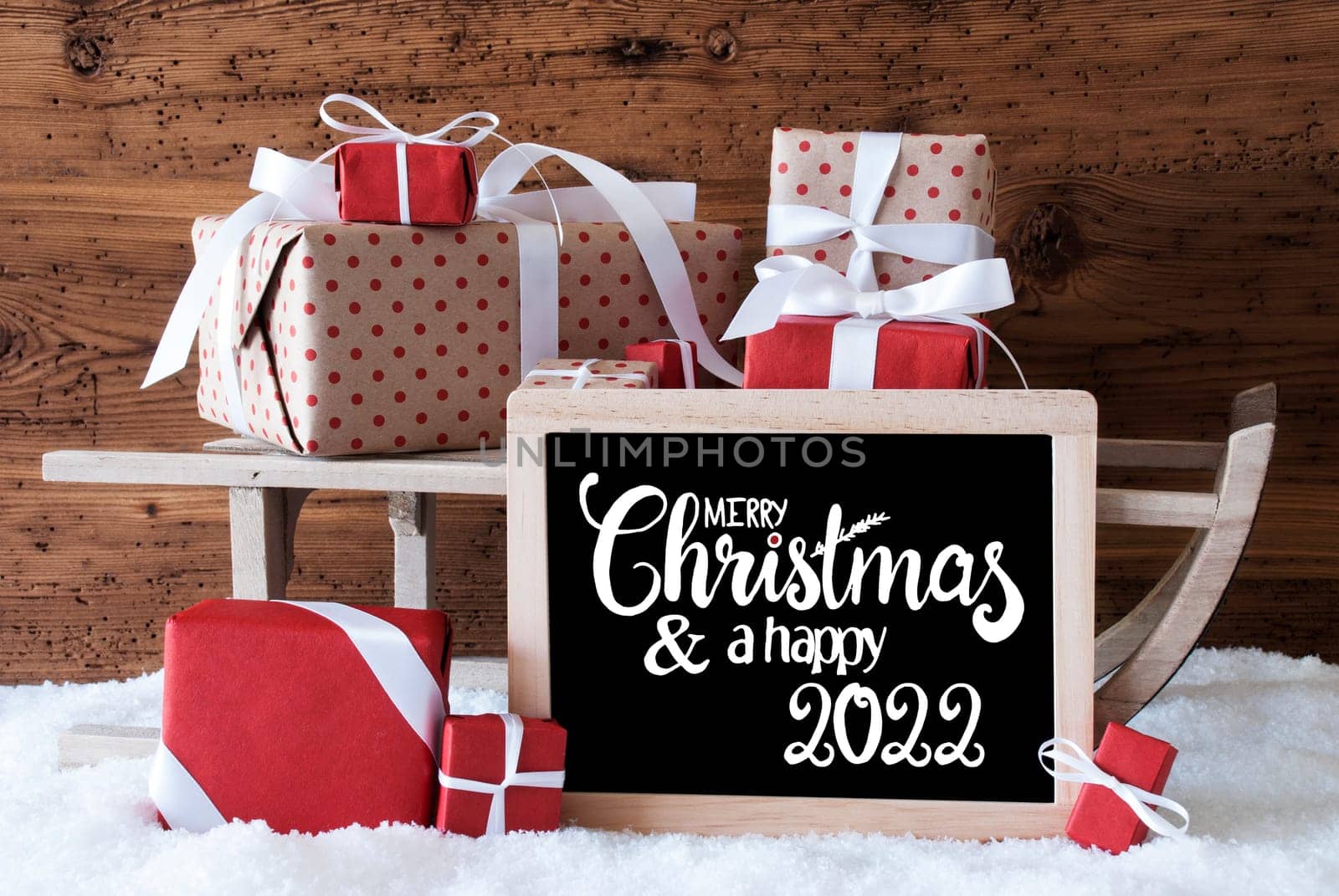 Blackboard With Egnlish Calligraphy Merry Christmas And A Happy 2020. Sled With Christmas Gift And Presents. Wooden Background With Snow.