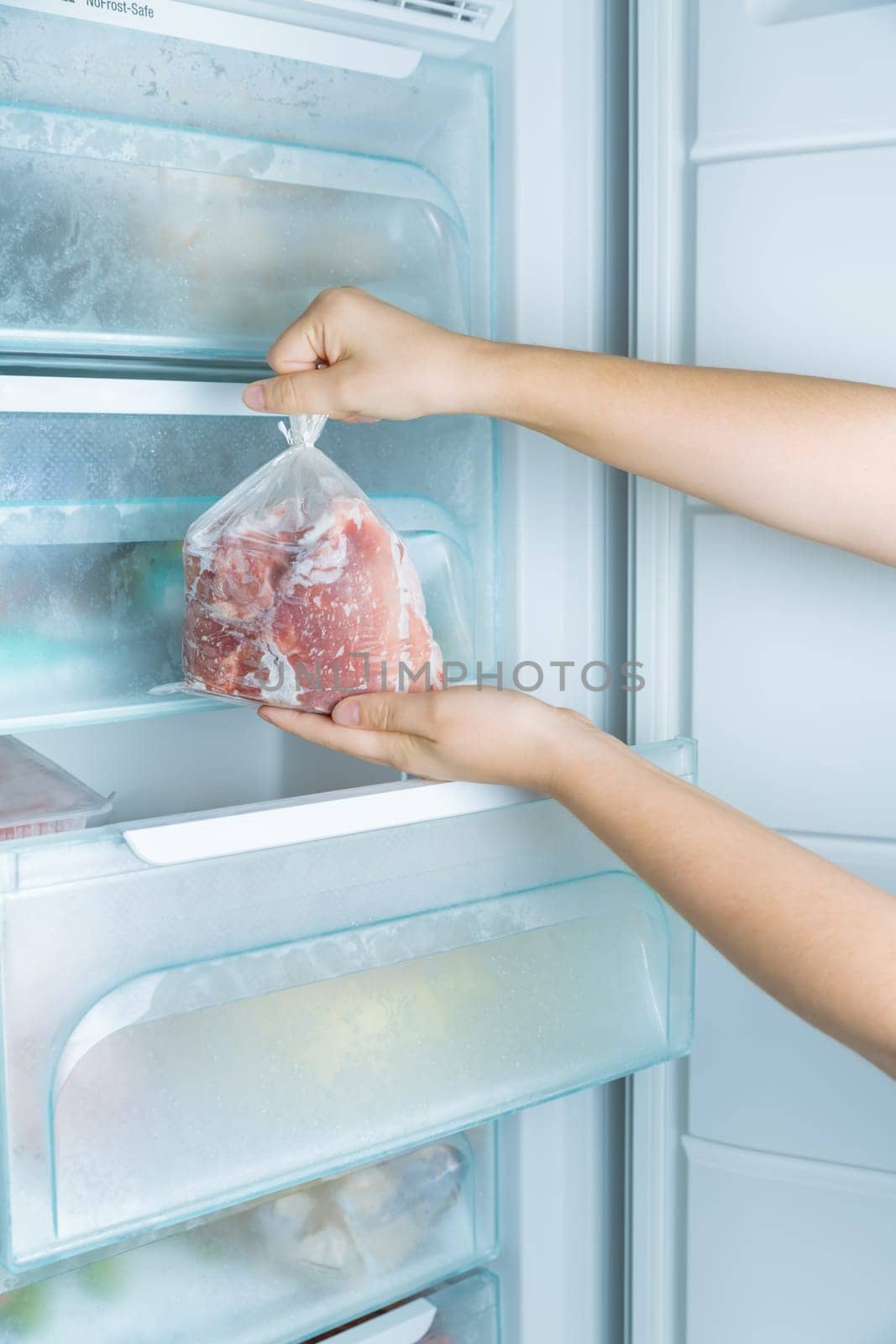 Taking frozen meat from the modern no-frost freezer