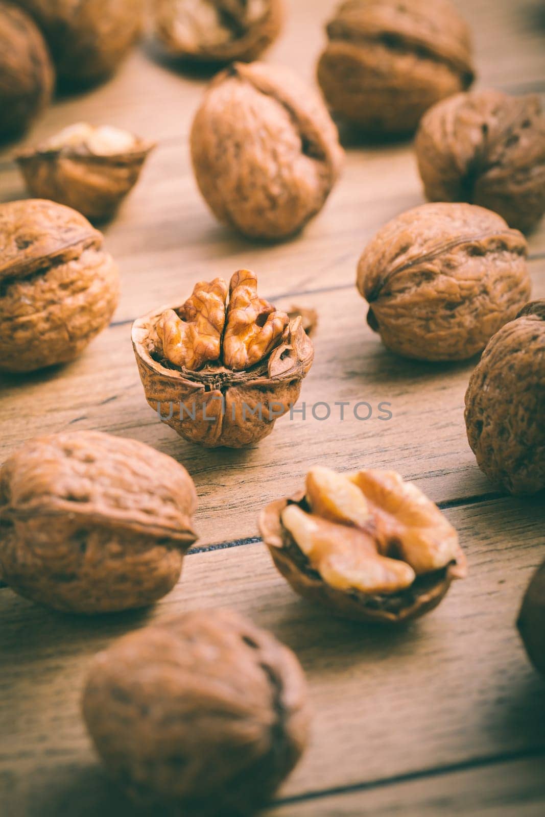 Organic walnuts with small nutcraker as baking ingredients on wooden background