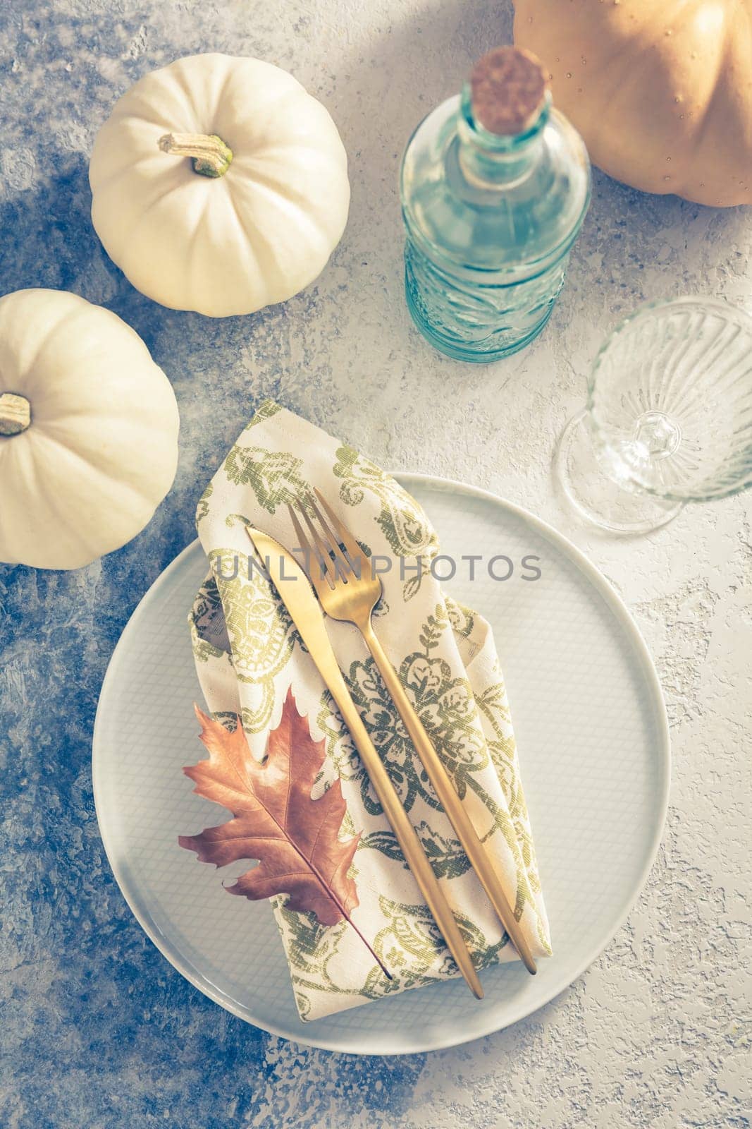 Place setting for Thanksgiving in vintage style with pumpkins and autumn leaf