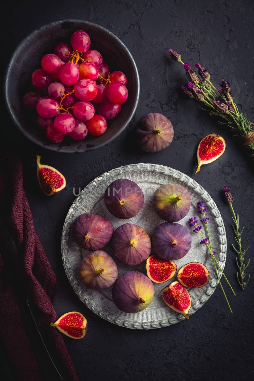 Organic fresh figs with red grapes and lavender on dark background