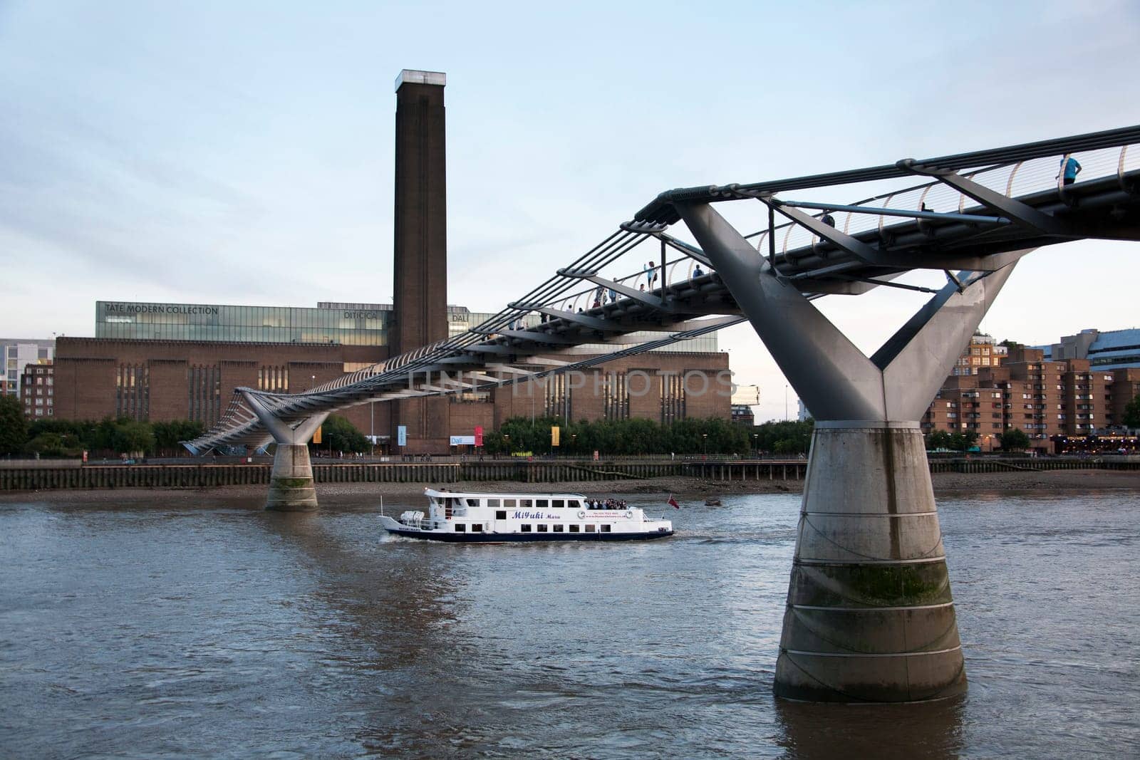 The River Thames with tourist boat and the Millennium Bridge and Tate Modern