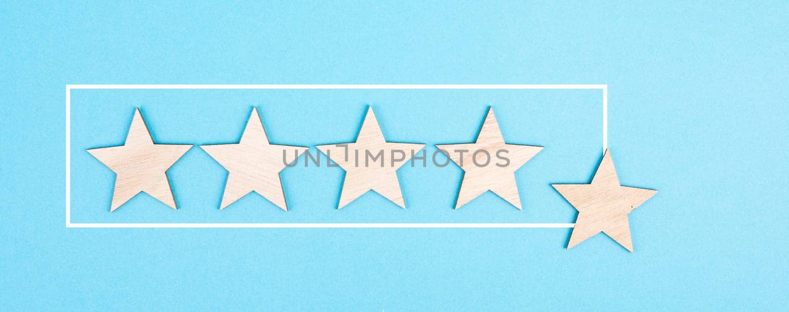 Five stars on a blue colored background, hand put the last star in the row, rating, giving feedback