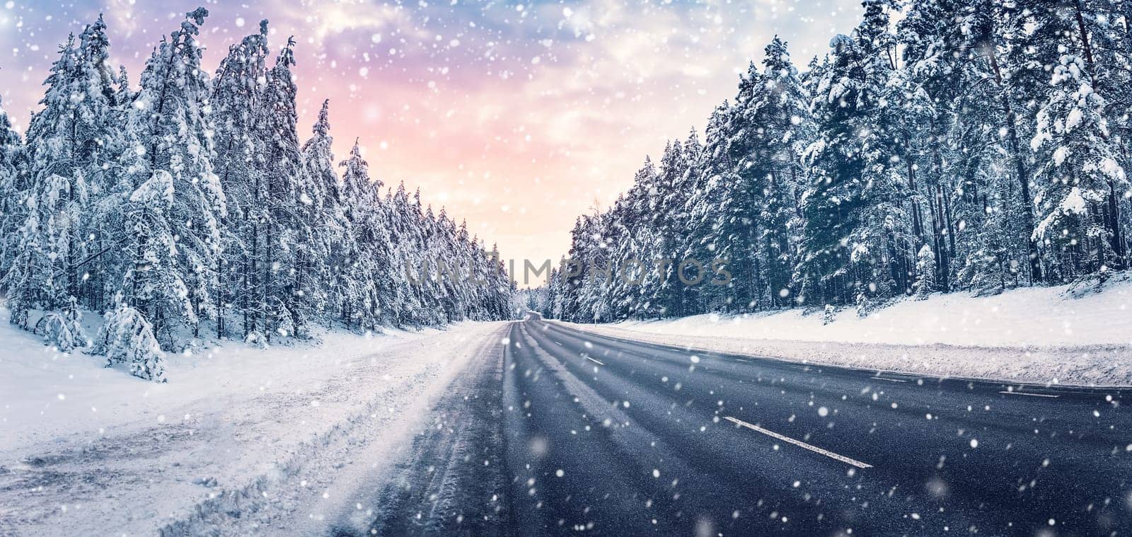 Beautiful view of the winter curve country road in snowstorm. Wavy snowy way in natural park.