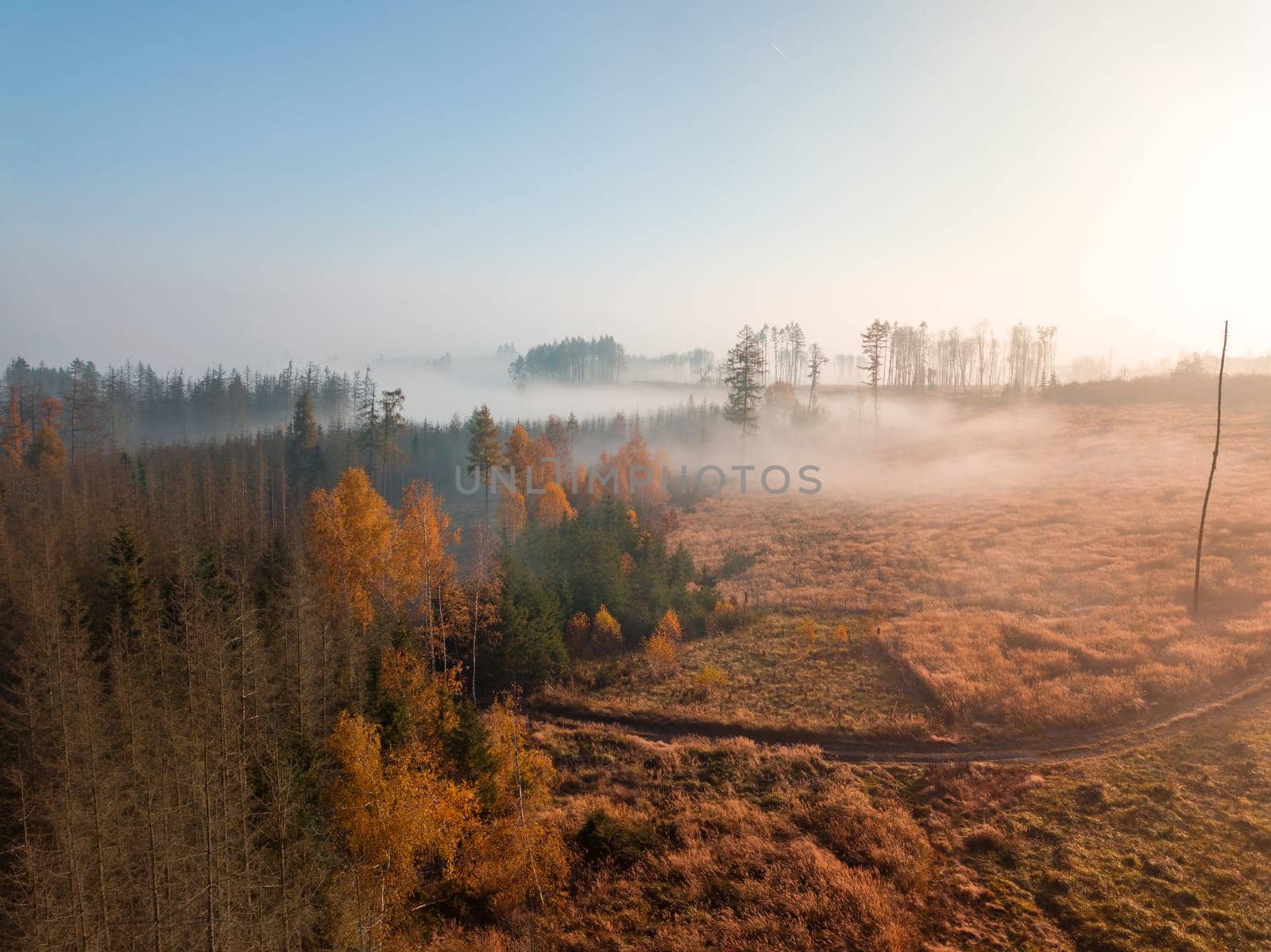 Aerial view of autumn sunrise countryside, traditional fall landscape with rising sun in Central europe. Foggy and misty sunrise. Frozen landscape from bird eye. Czech Republic,Vysocina highland
