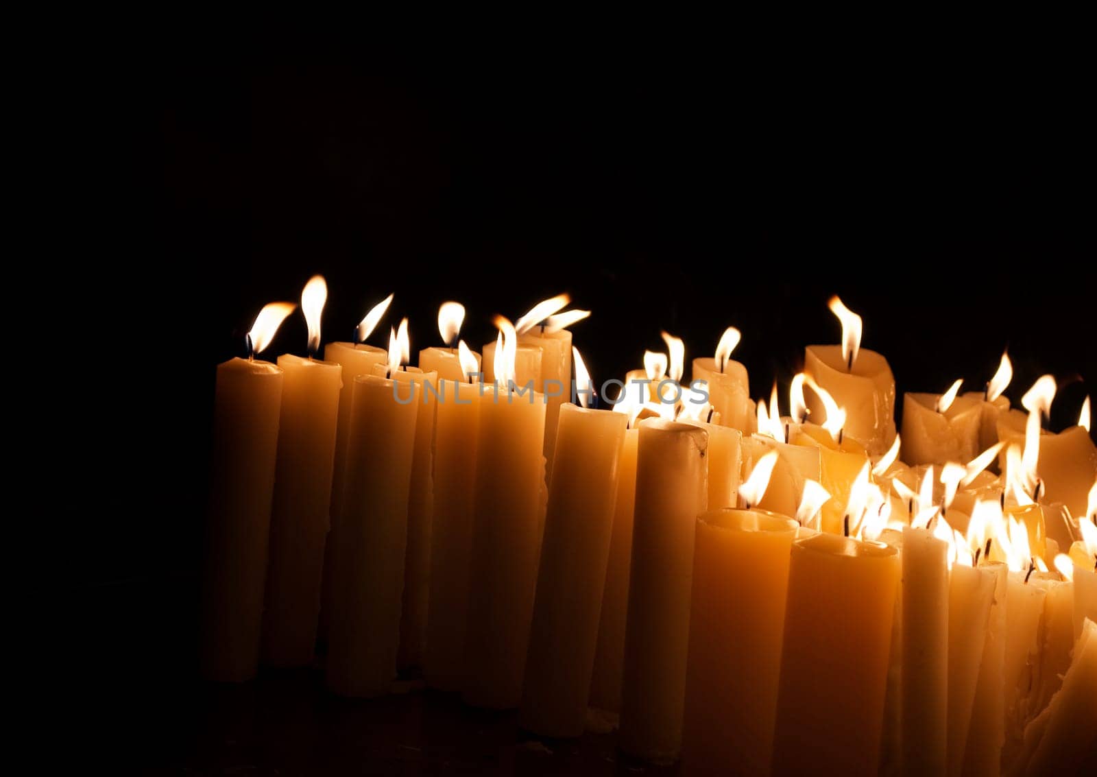 Lighted church candles in dark