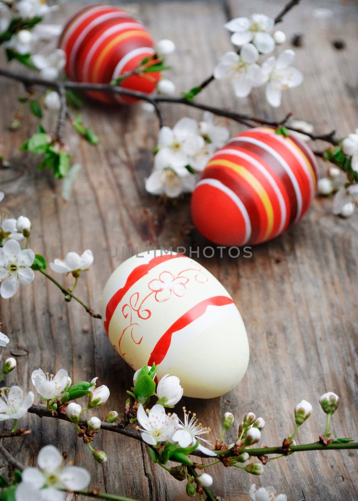 Easter eggs and cherry blossom on wooden plank