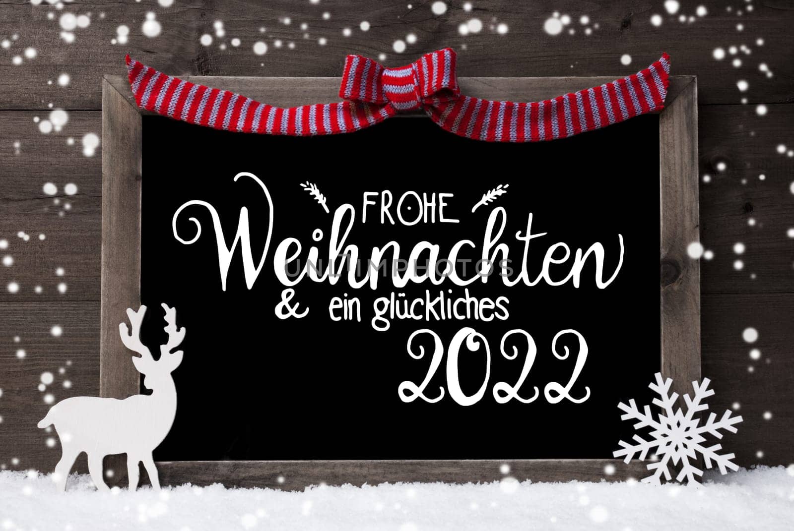 Chalkboard With German Calligraphy Frohe Weihnachten Und Ein Glueckliches 2022 Means Merry Christmas And A Happy 2022. Decoration Like Deer And Bow. Gray Wooden Background With Snow And Snowflakes