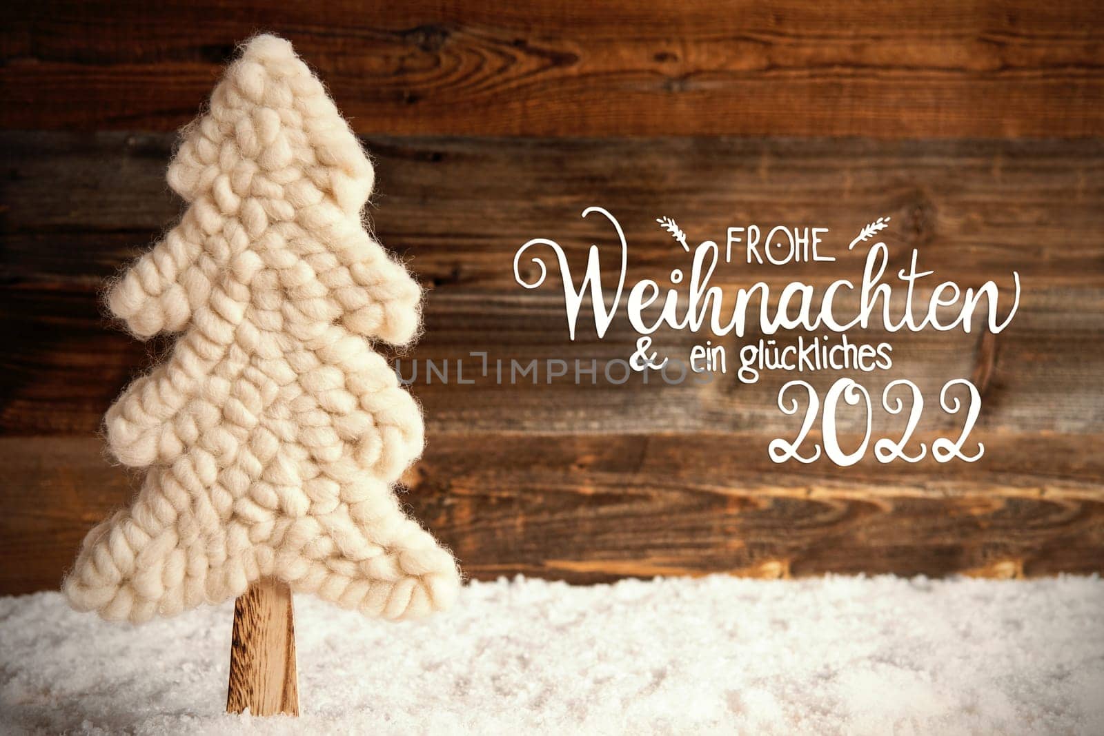 German Calligraphy Frohe Weihnachten Und Ein Glueckliches 2022 Means Merry Christmas And A Happy 2022. White Fabric Christmas Tree With Snow. Brown Rustic Wooden Background