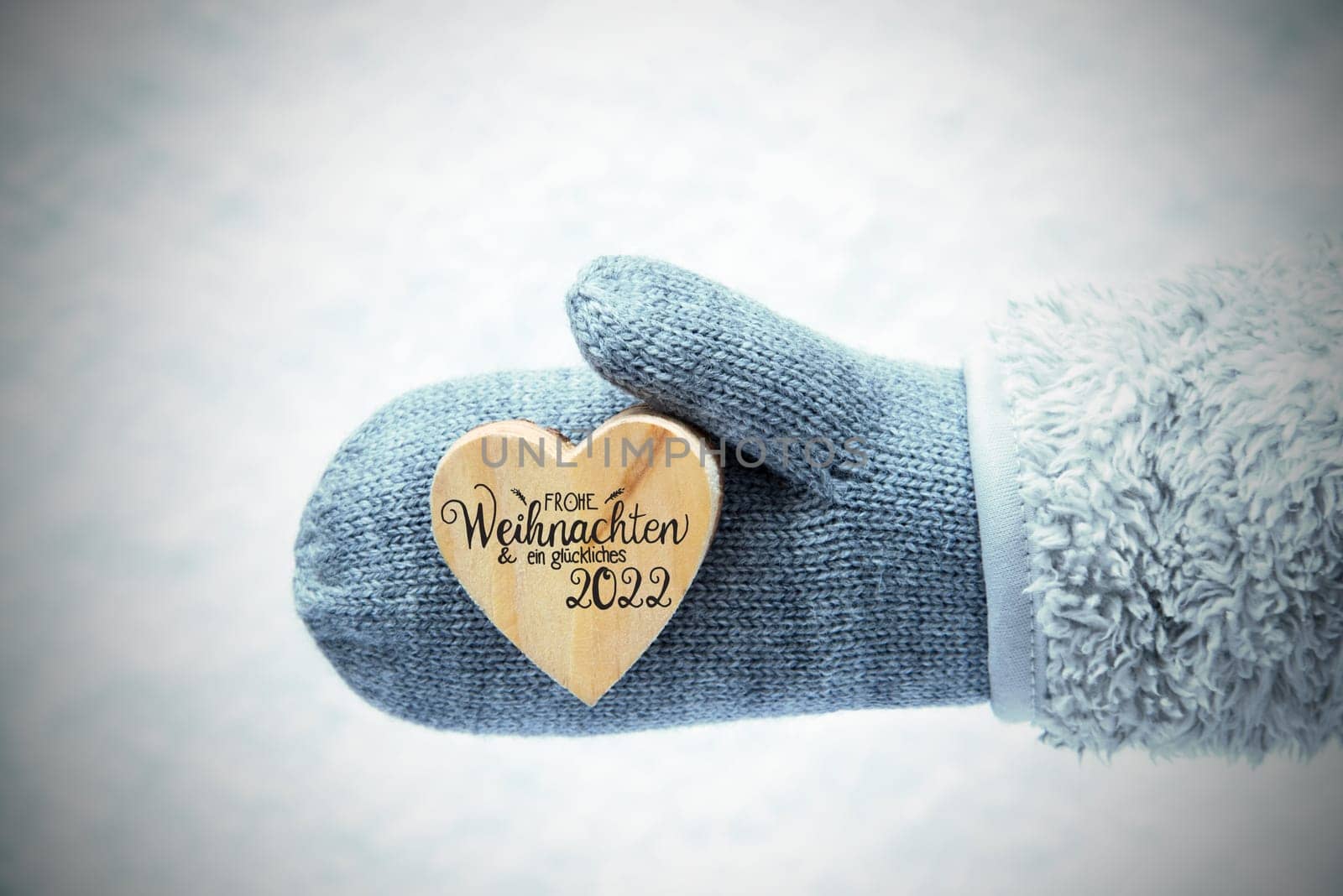 Heart With German Calligraphy Frohe Weihnachten Und Ein Glueckliches 2022 Means Merry Christmas And A Happy 2022. Human Hand In A Glove With Fleece And Snow.