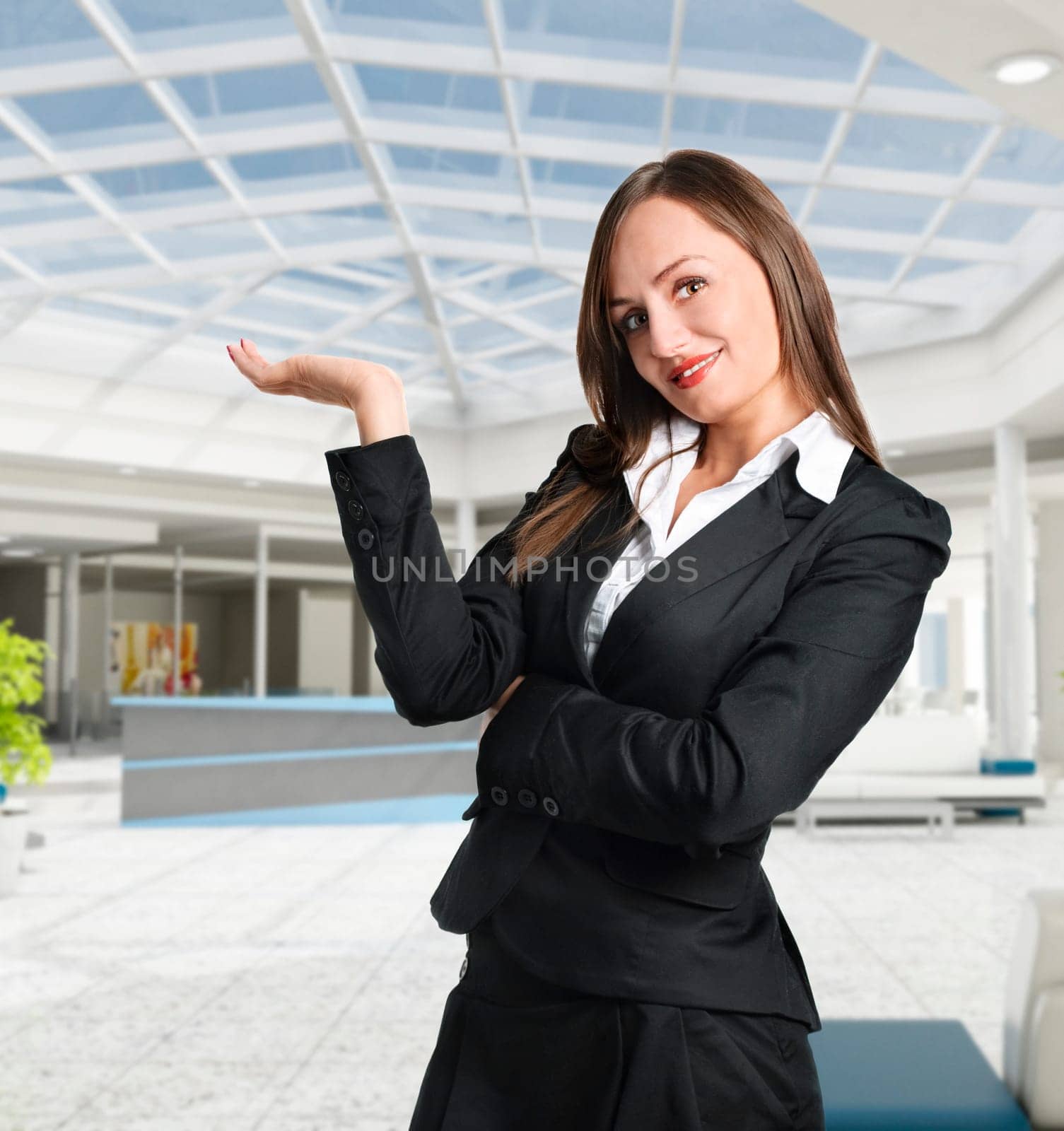 Smiling business woman showing corporate building