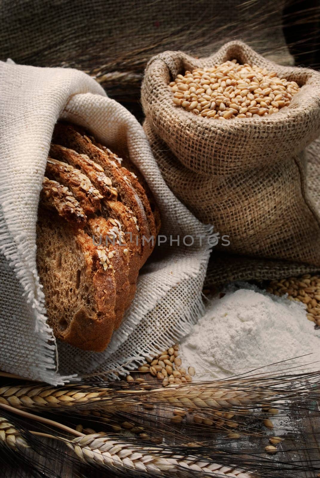 .Bread and wheat ears on vintage wooden board