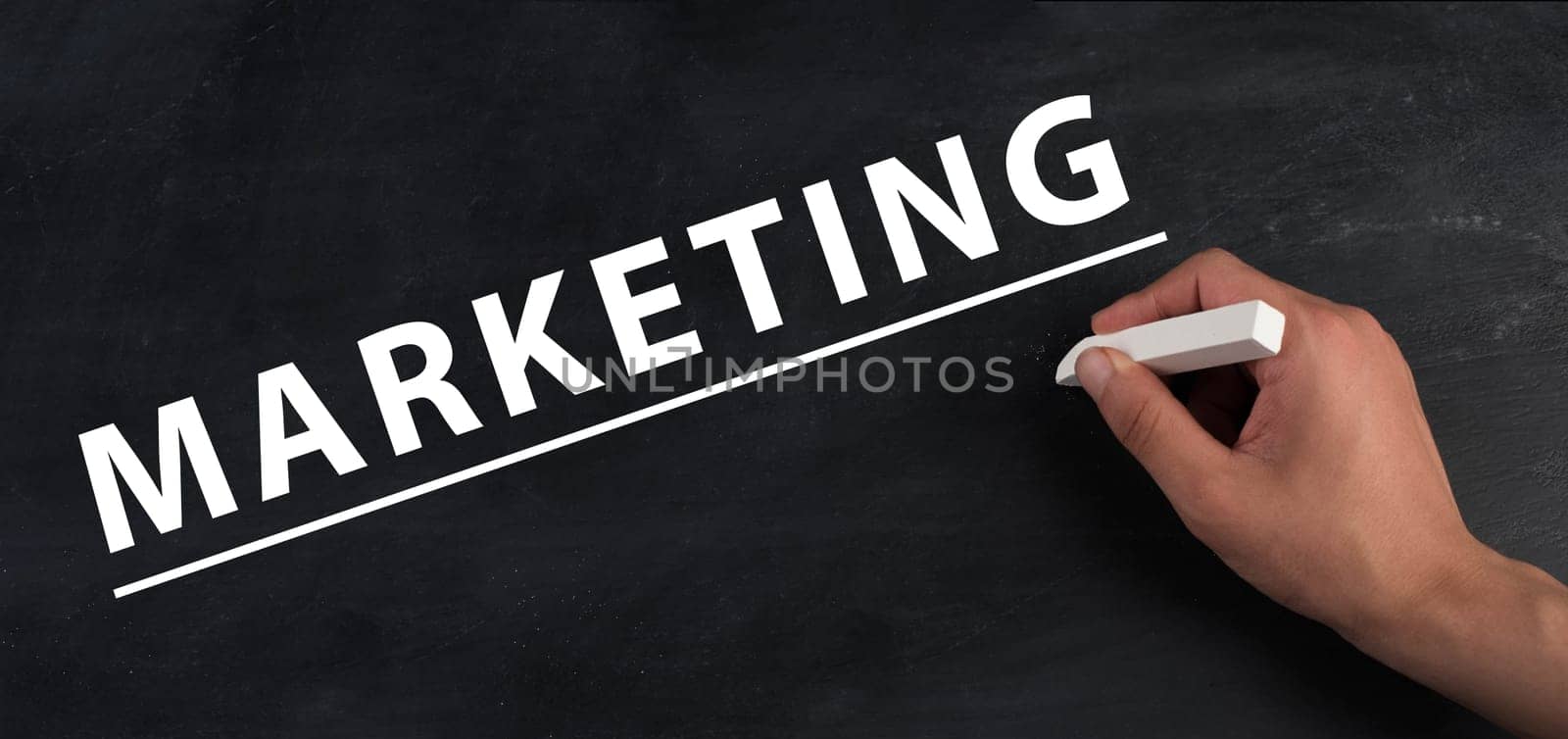 The word marketing is standing on a black chalkboard, handwritten , branding, advertising business, strategy for brand
