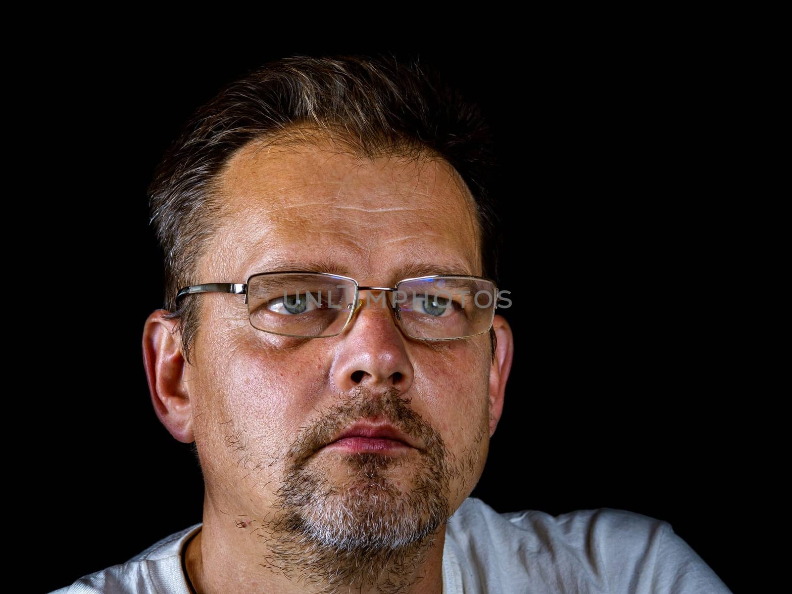 Portrait of a bearded man with glasses for vision. A man with a gray beard. Portrait. Glasses for sight. The face of an adult. The age of the people. Black background. Fathers day.