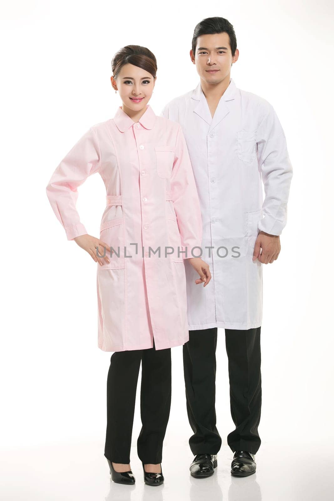 Staff wear coats in front of white background