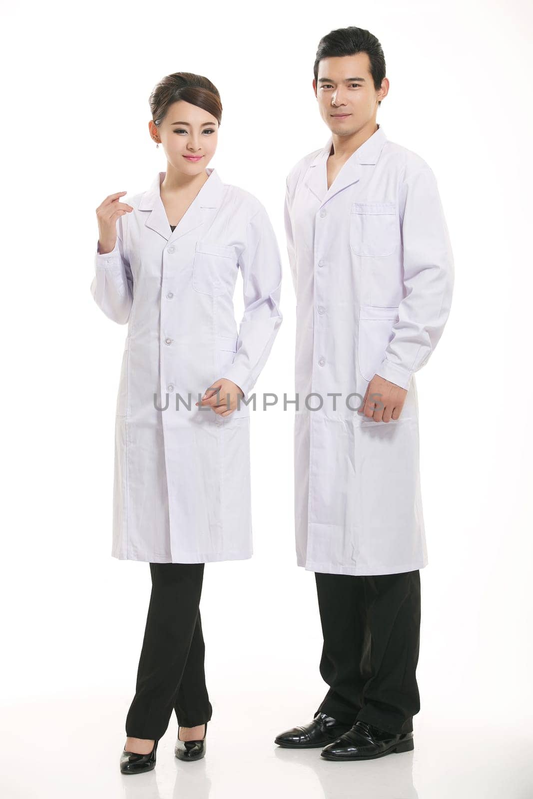Staff wear coats in front of white background