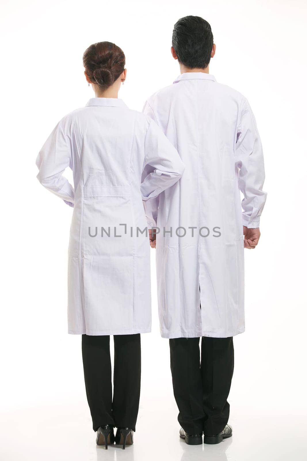 Staff wear coats in front of white background