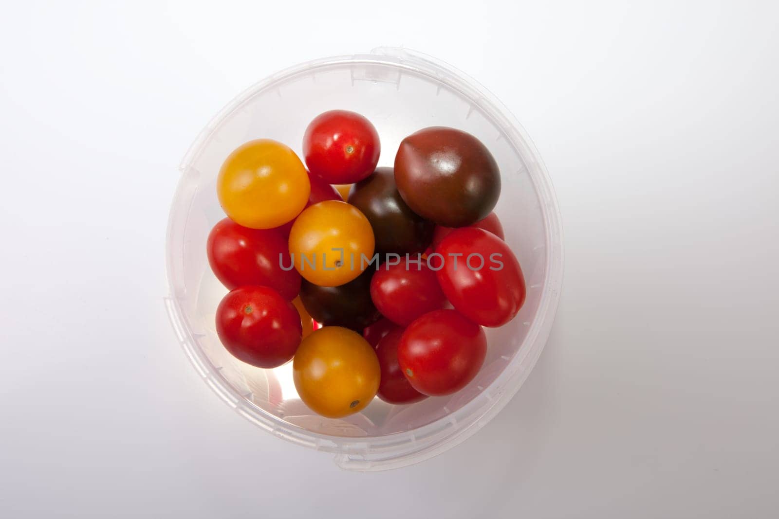 Bucket of colorful cherry tomatoes. Isolated over white background