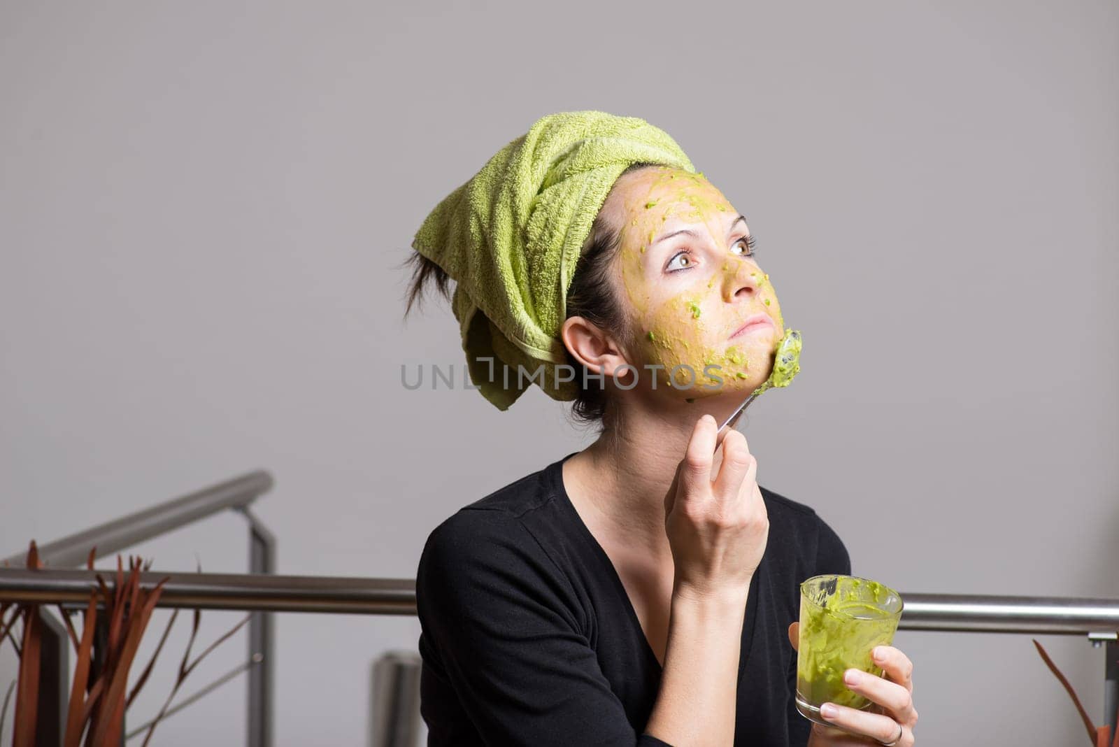 Attractive young woman with spots using a facial avocado mask
