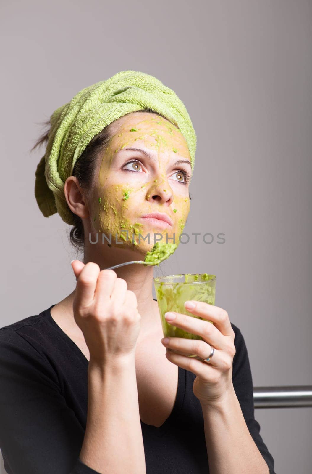Attractive young woman with spots using a facial avocado mask