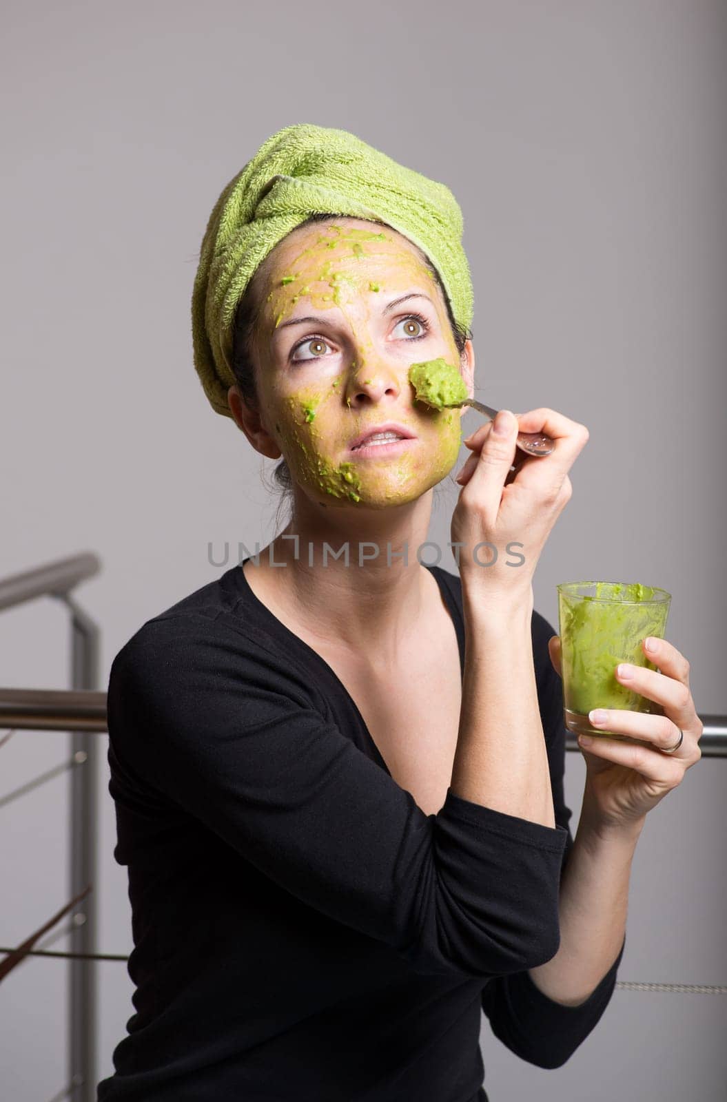 Attractive young woman with spots using a facial avocado mask
