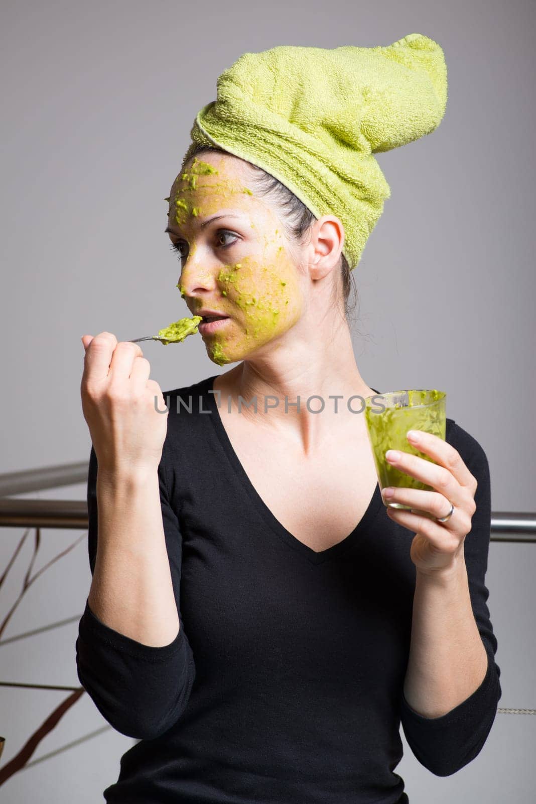 Attractive young woman with spots using a facial avocado mask