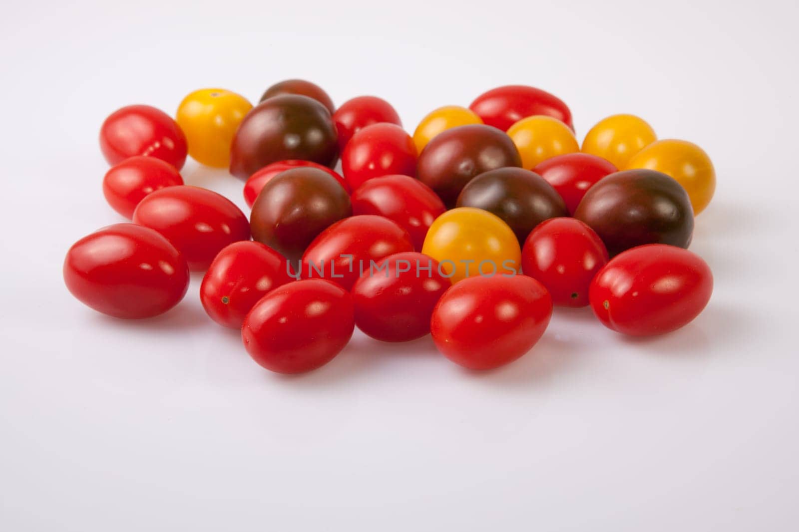 Handful of colorful cherry tomatoes. Isolated over white background