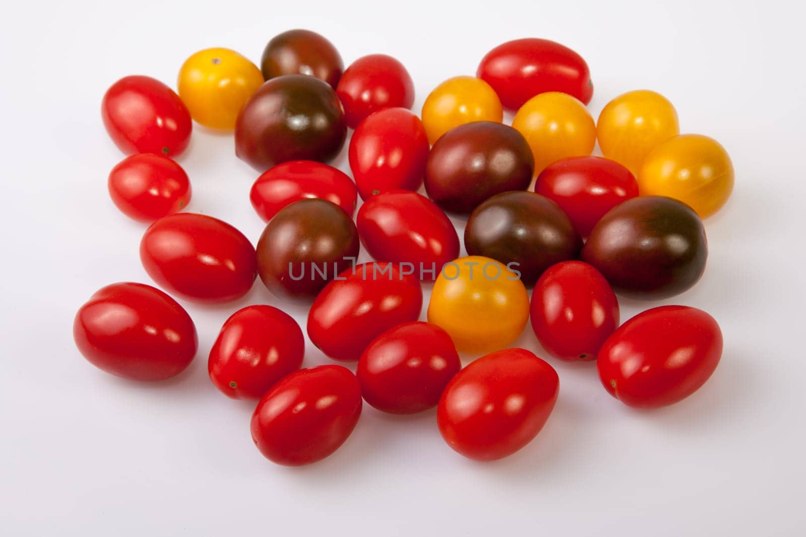 Handful of colorful cherry tomatoes. Isolated over white background