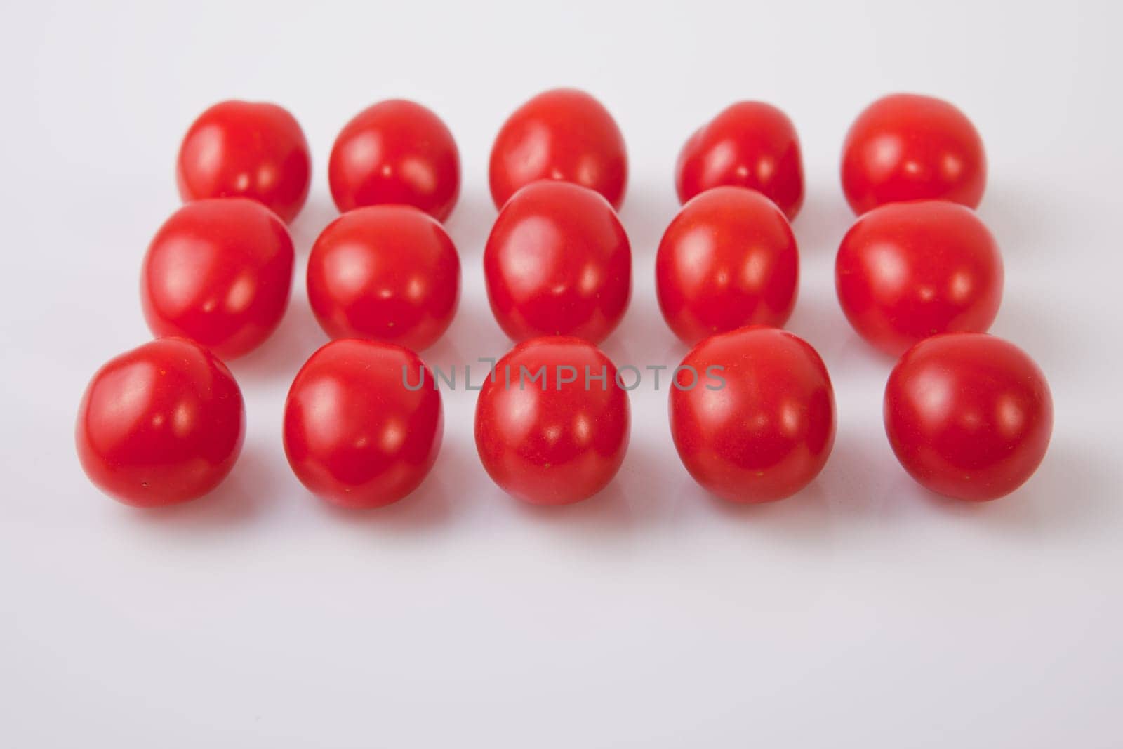 Red shiny cherry tomatoes. Isolated over white background