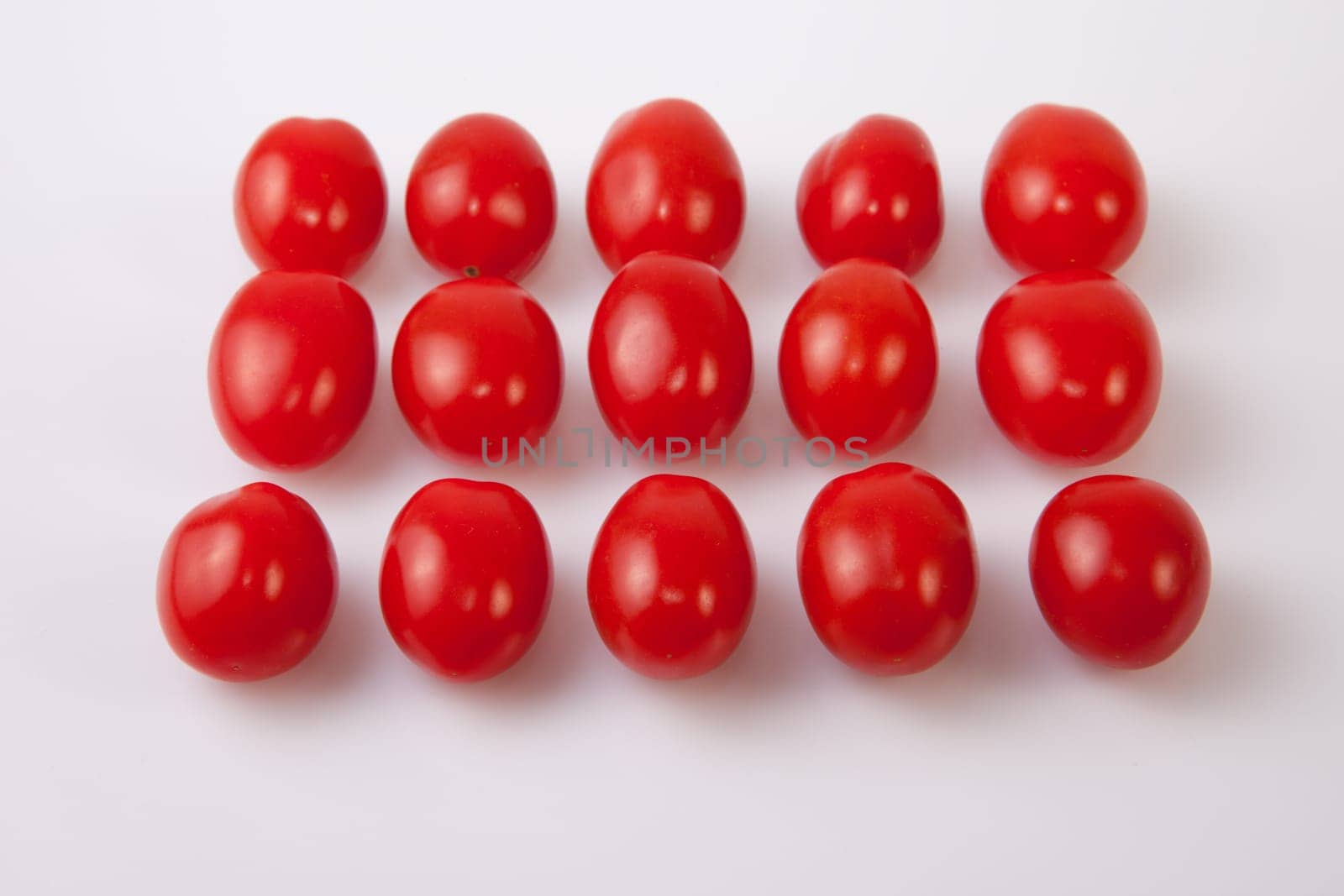 Red shiny cherry tomatoes. Isolated over white background