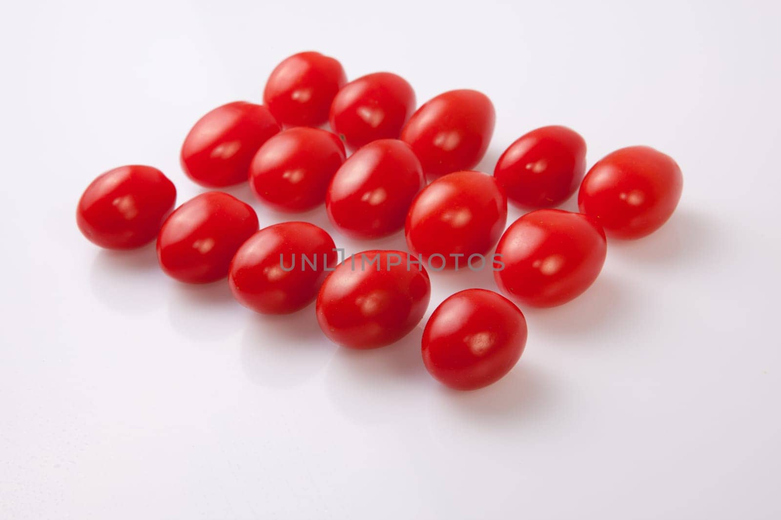 Red shiny cherry tomatoes. Isolated over white background