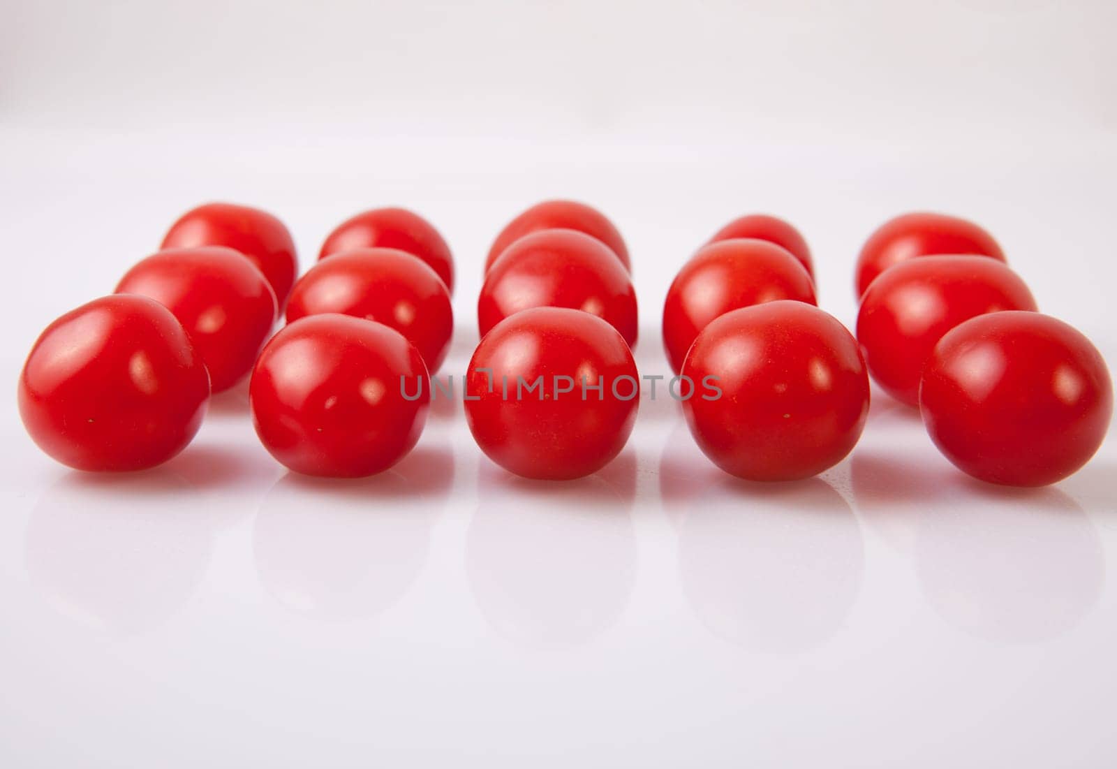 Red shiny cherry tomatoes. Isolated over white background