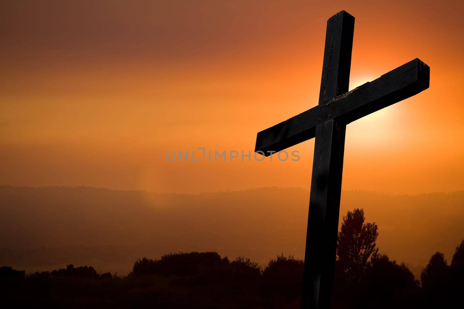 cross silhouette with the sunset as background