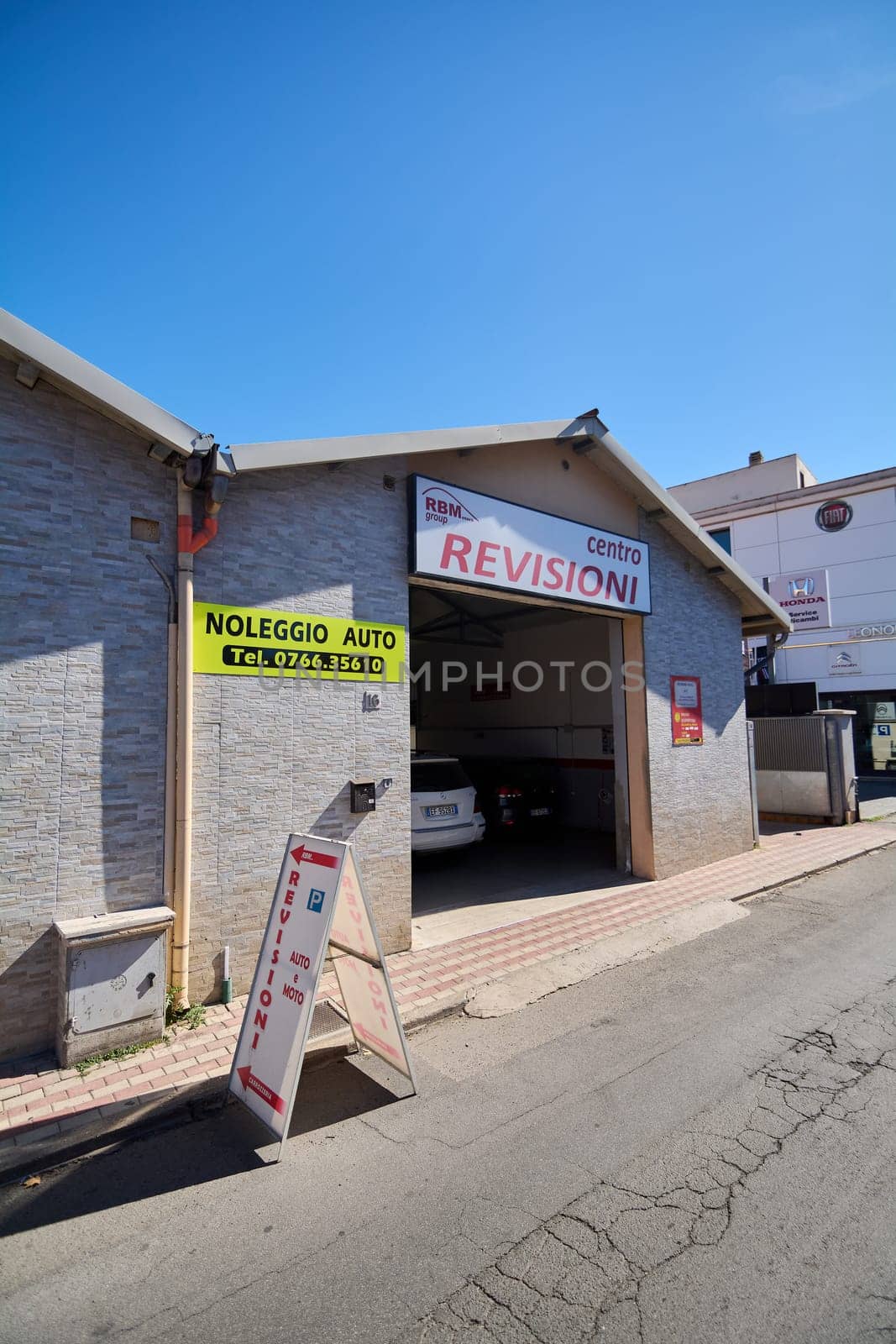 Civitavecchia, Italy - January 26, 2025: Exterior of an Italian vehicle inspection center with clear signage  contact details for rentals and a parking sign in front Urban environment in Civitavecchia