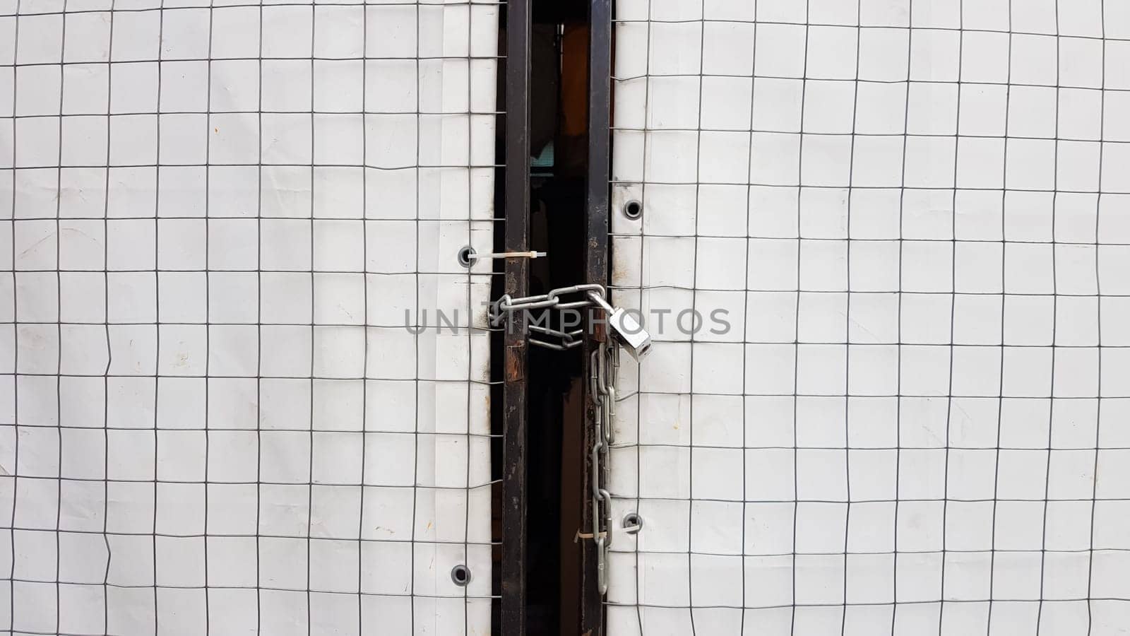Closed padlock on a hangar from a grid and a white banner.