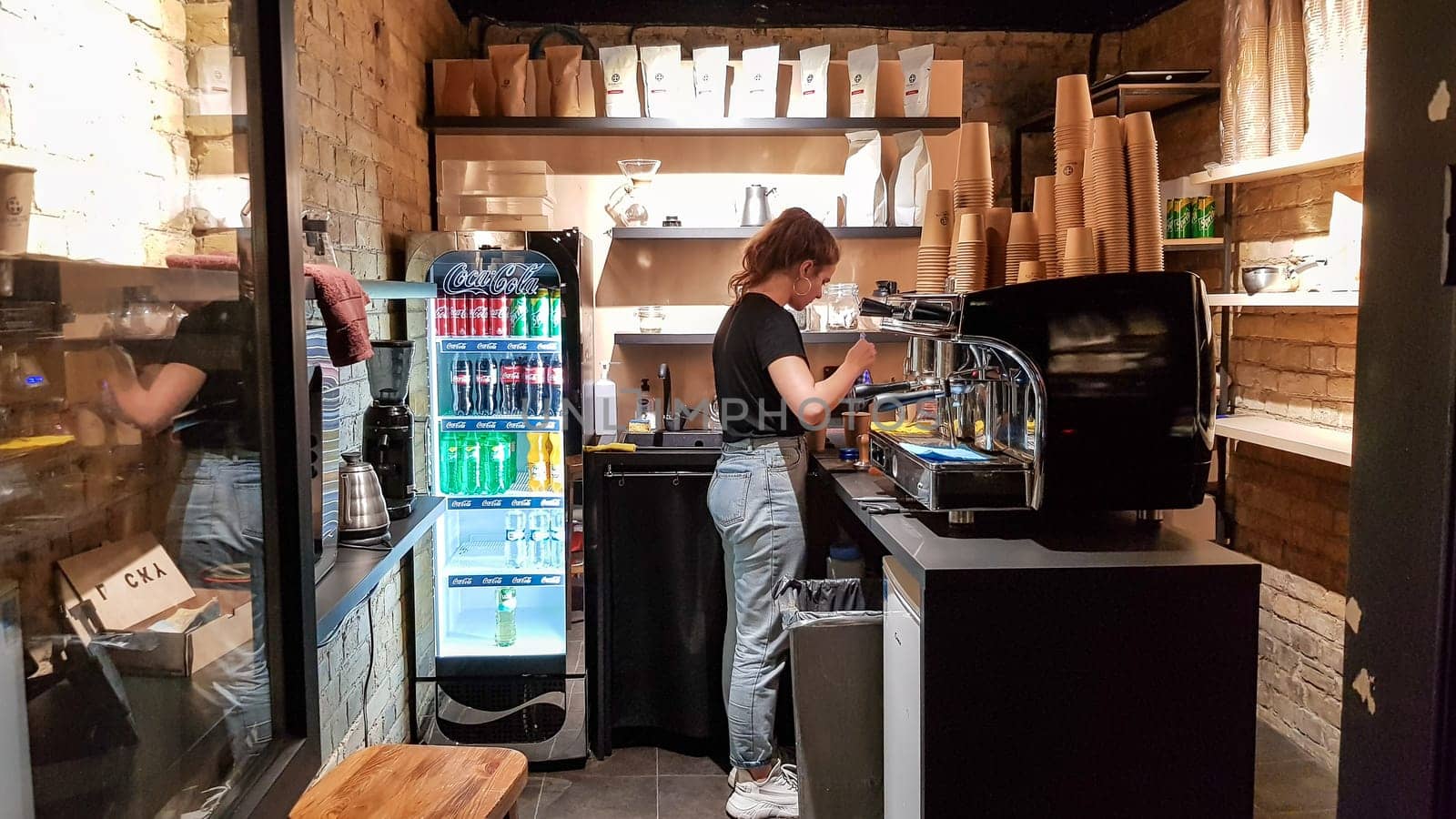 Ukraine, Kiev - March 06, 2020. Prepare a work order concept. Barista girl makes coffee. Cafe and counter with coffee equipment, espresso coffee machine, coffee grinder, cups for making drinks