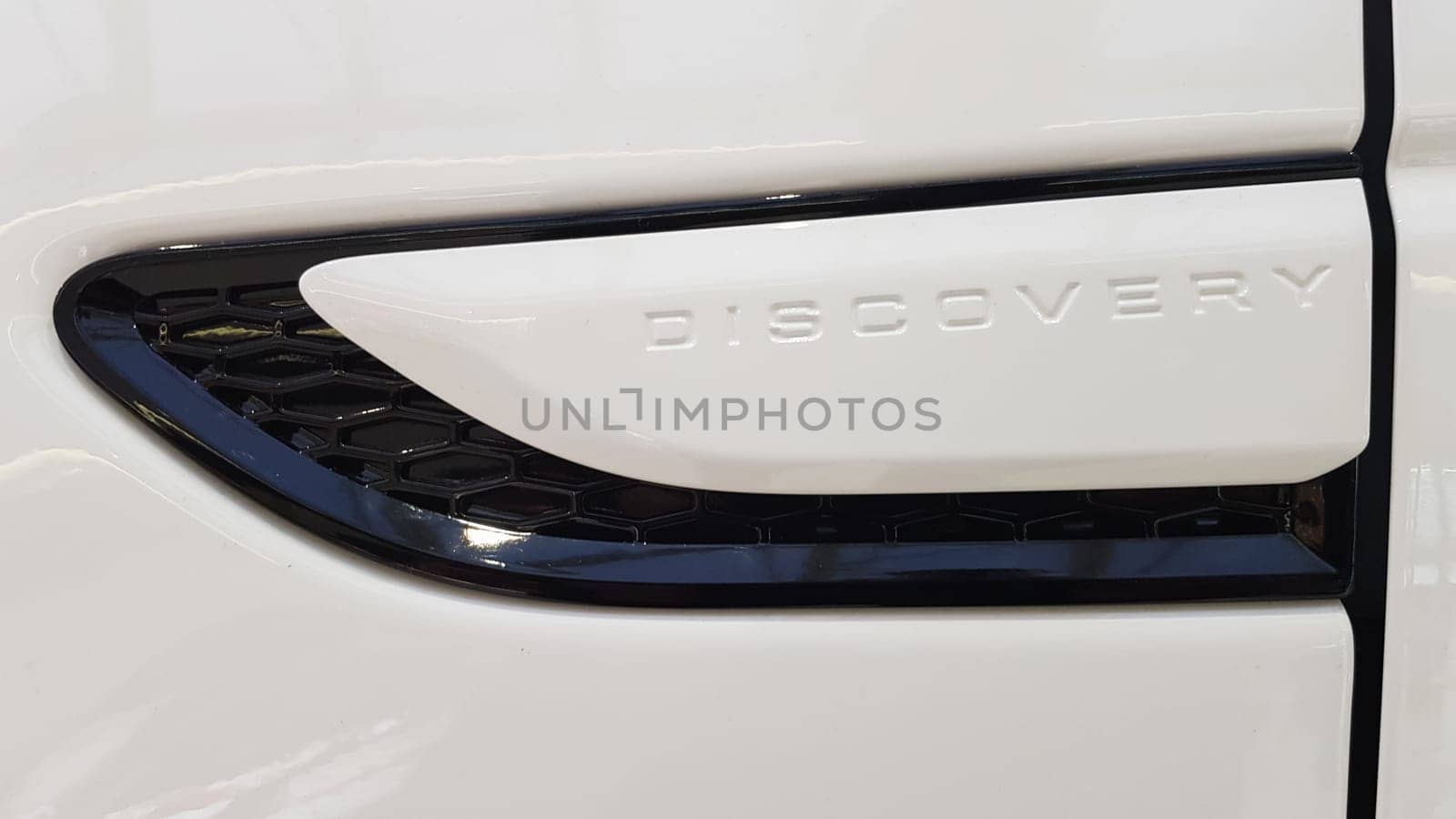 Ukraine, Kiev - March 27, 2020: new white Land Rover Discovery Sport 2019. Side view of the wing and part of the door with the inscription. Medium SUV.