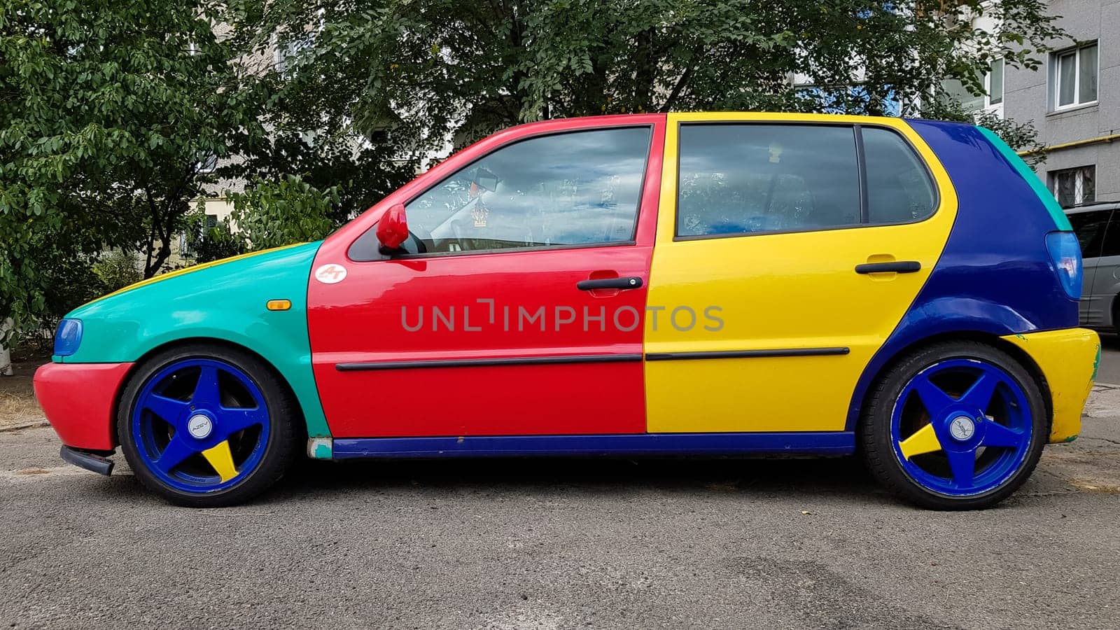 Ukraine, Kiev - March 27, 2020: Volkswagen Golf 4 model with a hatchback body with multi-colored body parts. Funny and bright car in red, blue, yellow. car painted in different colors.