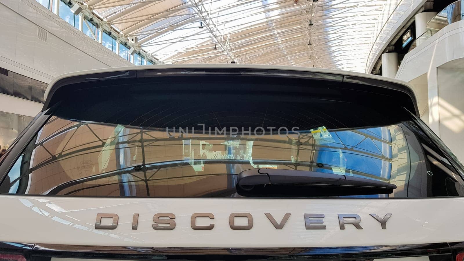 Ukraine, Kiev - March 27, 2020: Land Rover Discovery Sport shiny modern white car at the exhibition. Body, headlights close-up, rear and front view, chrome grille, car logo