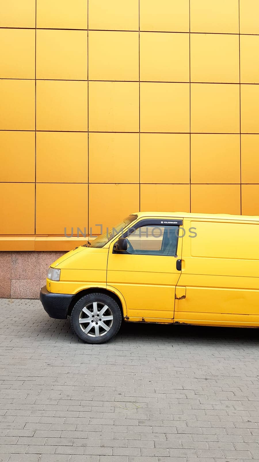 Ukraine, Kiev - March 27, 2020: Yellow Transporter in yellow on a background of a yellow building