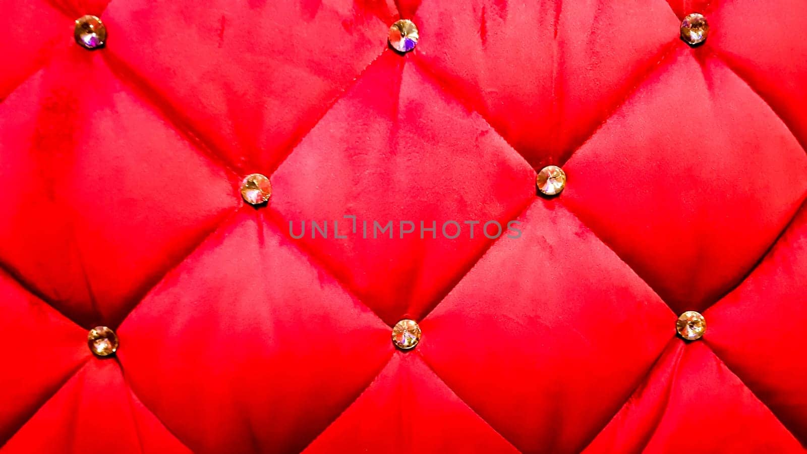back of a red sofa. Red fabric texture background, Chesterfield style decoration with buttons, retro fabric. Retro diamond-shaped soft style fabric decorate with buttons. red velvet background.