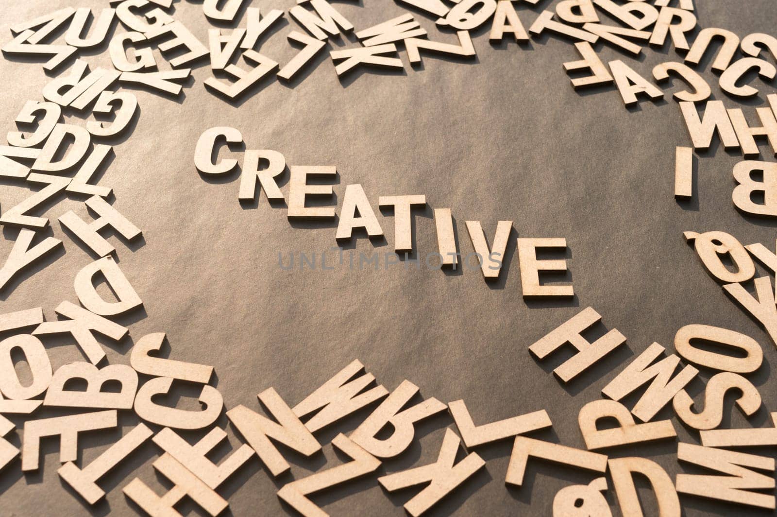 Creative Word In Wooden Cube Alphabet Letters Top View On A rustic paper Background.