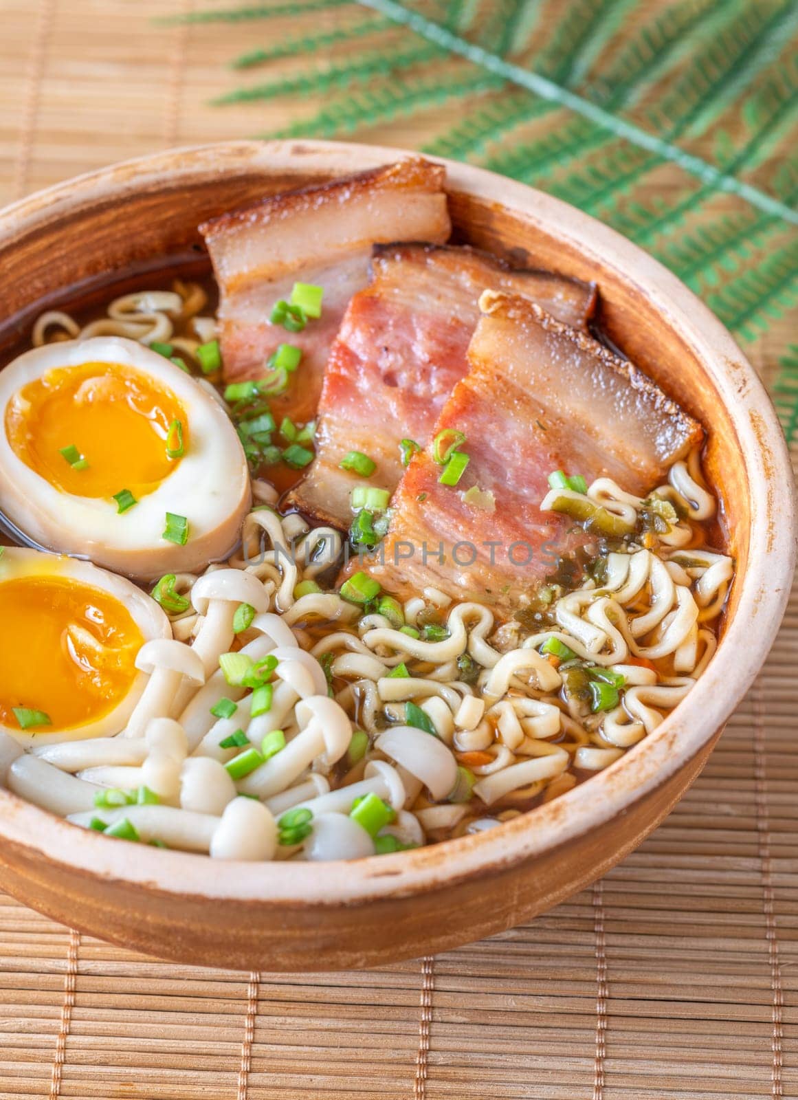 A steaming bowl of ramen filled with noodles, tender pork, and savory toppings