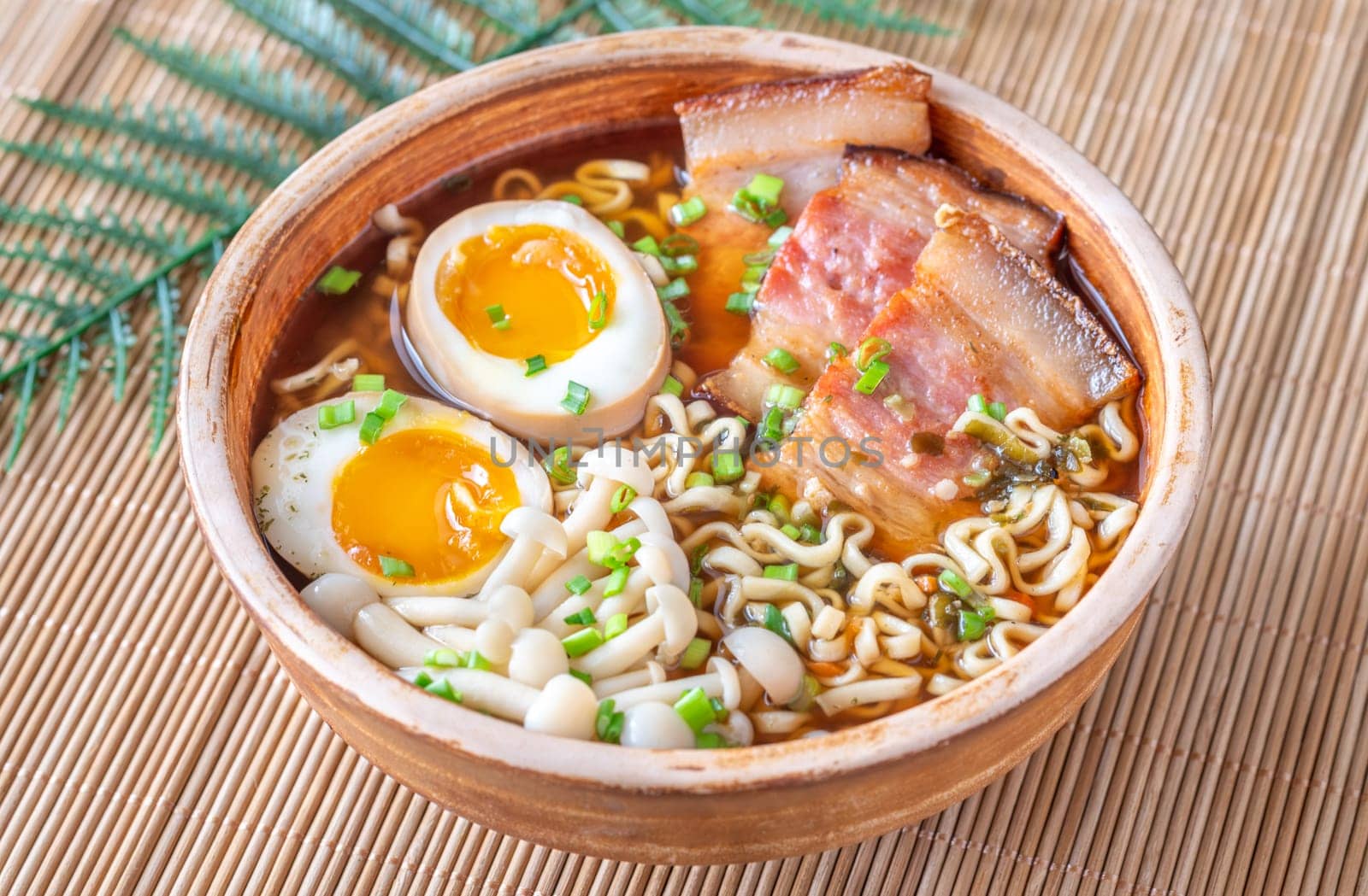 A steaming bowl of ramen filled with noodles, tender pork, and savory toppings
