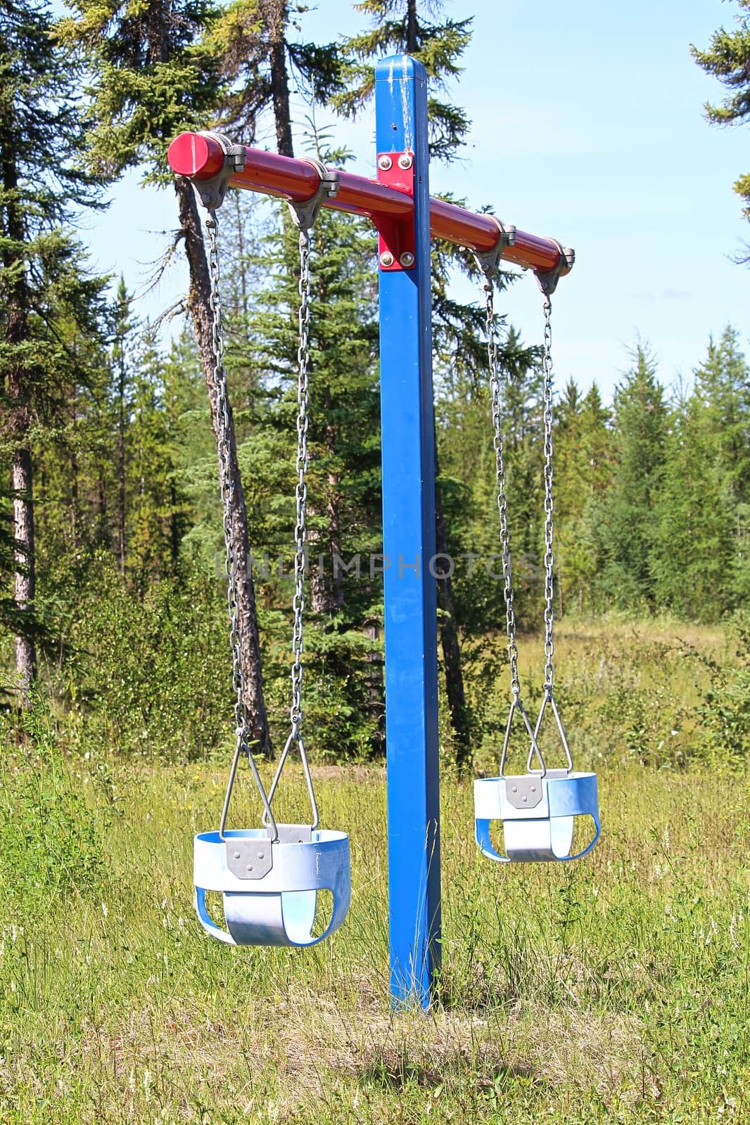 Teo baby swings at a rural playground.