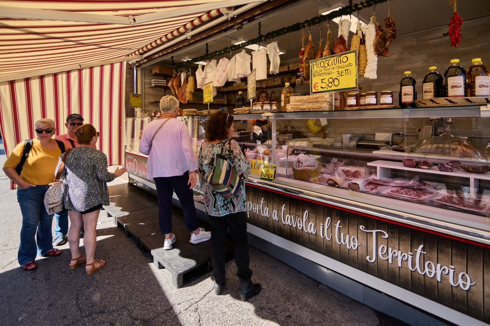 Civitavecchia, Italy - January 26, 2025: Market scene and people buying local delicacies The food stand is full of cold cuts, cheeses and other traditional products that highlight the local gastronomy