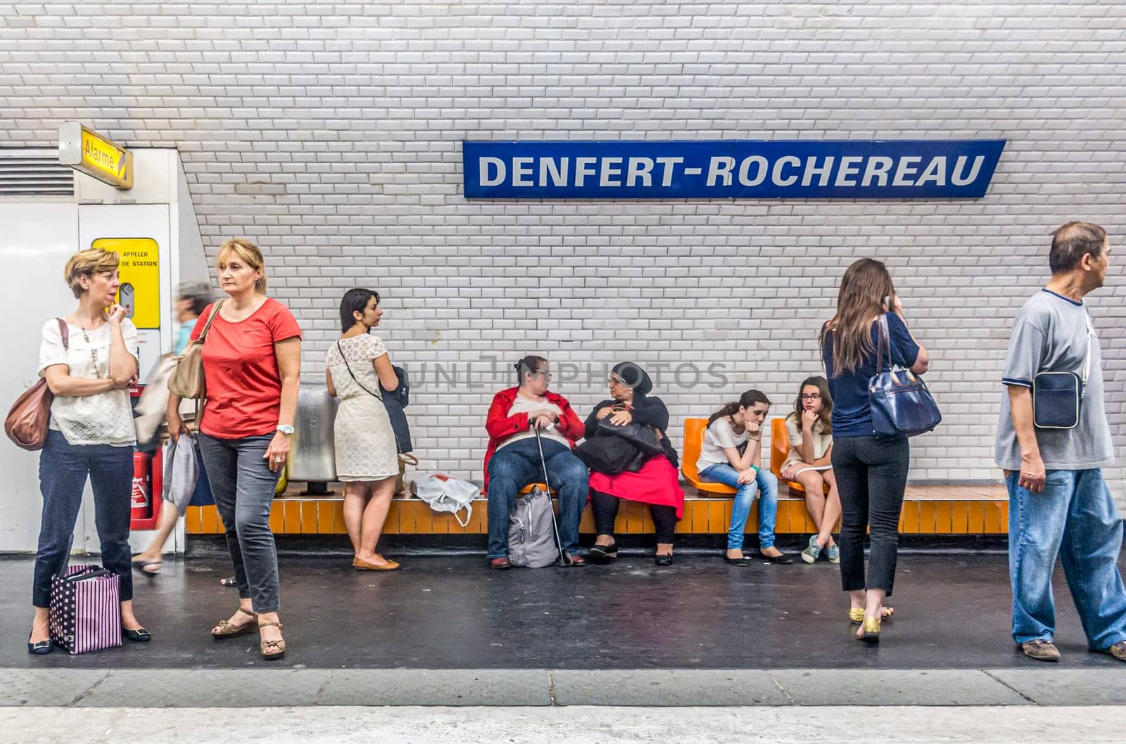 Paris, France - June 12, 2015:  people wait in the Metro station for next arriving train.