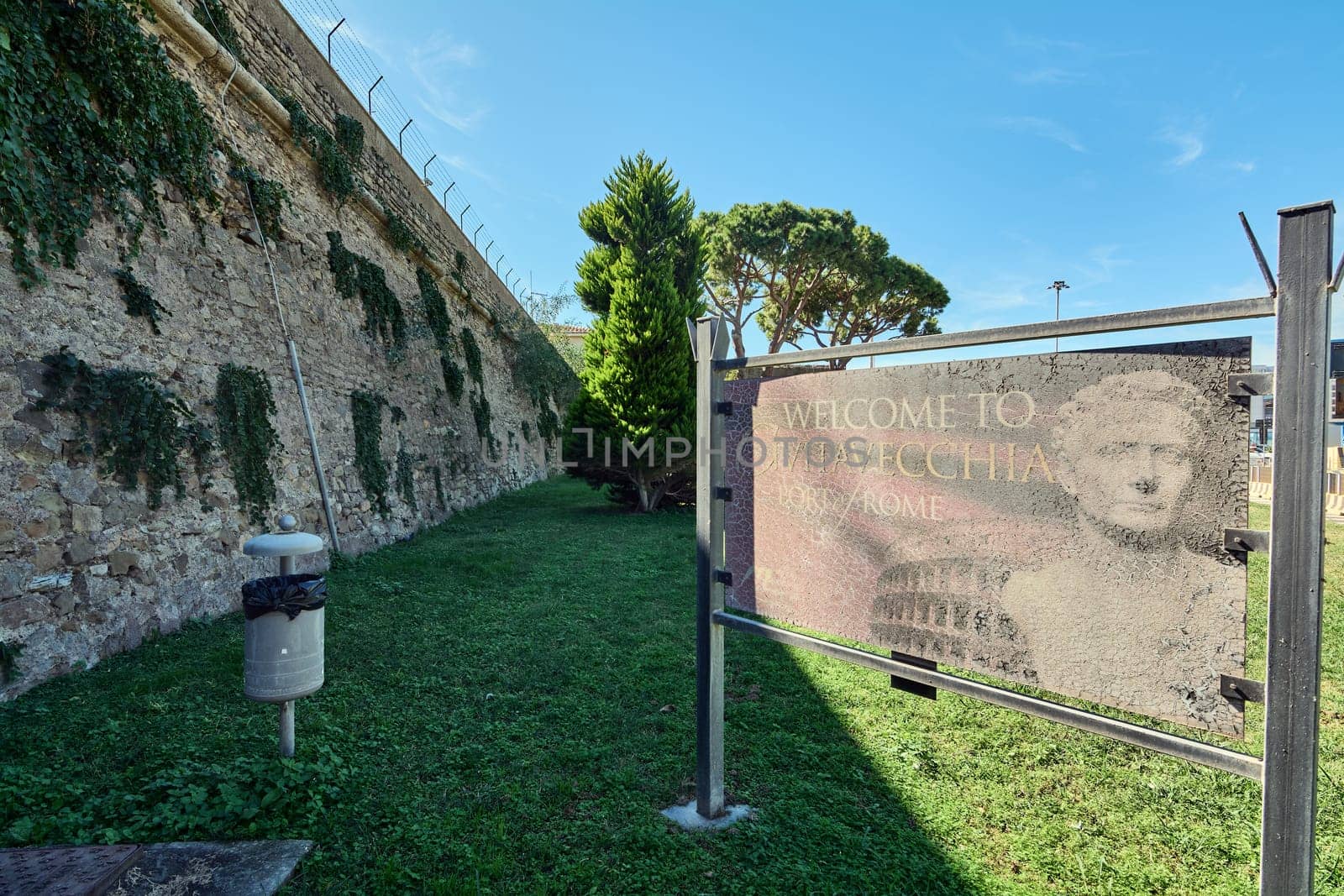 Civitavecchia, Italy - February 02, 2025: A deteriorated welcome board with ancient Roman motifs marks the entrance to this maritime city. Concept: travel, heritage, architecture