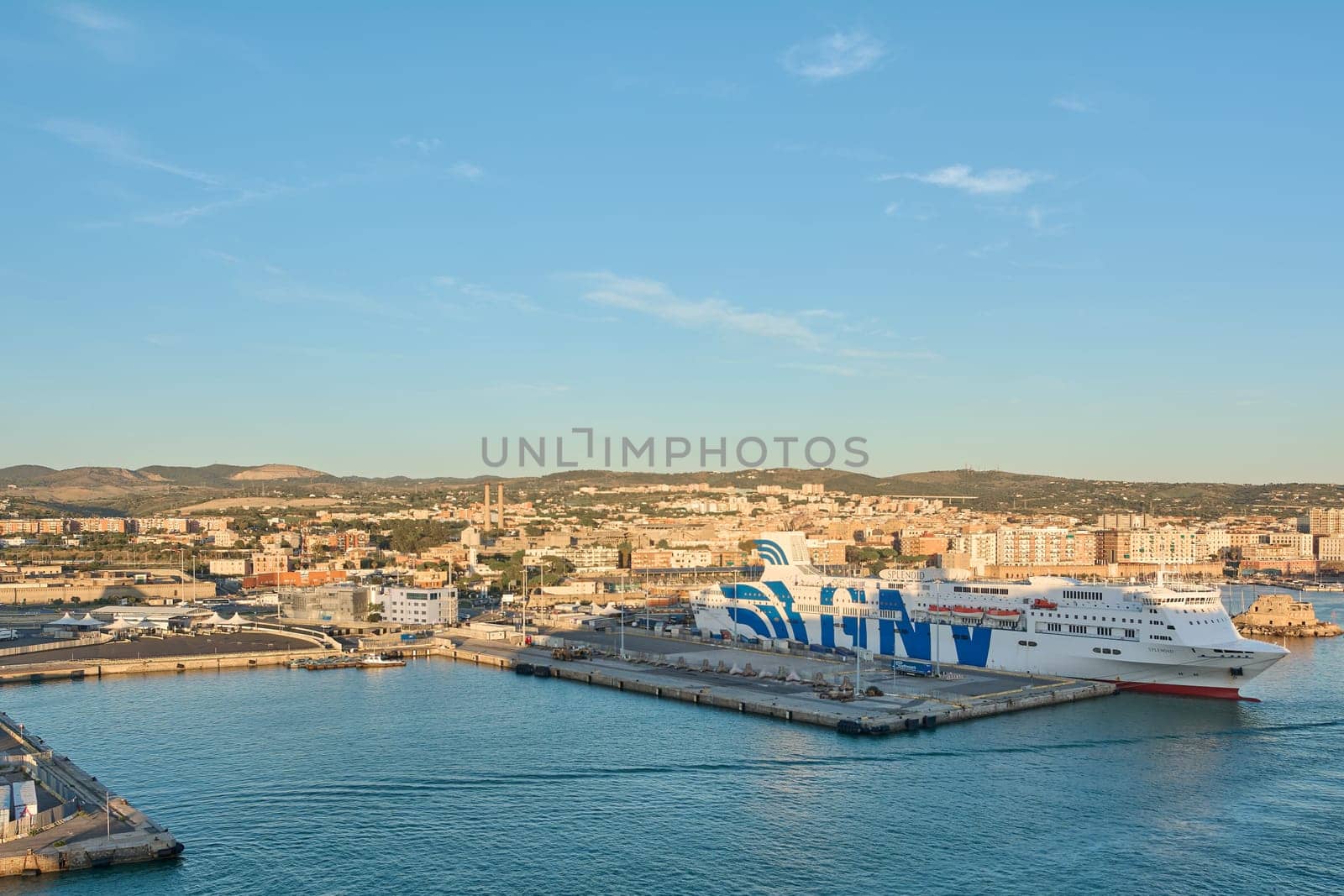 Civitavecchia, Italy - February 02, 2025: Aerial view of a commercial harbor with freight trucks and shipping containers, illustrating maritime infrastructure. Concept: shipping, logistics, supply.