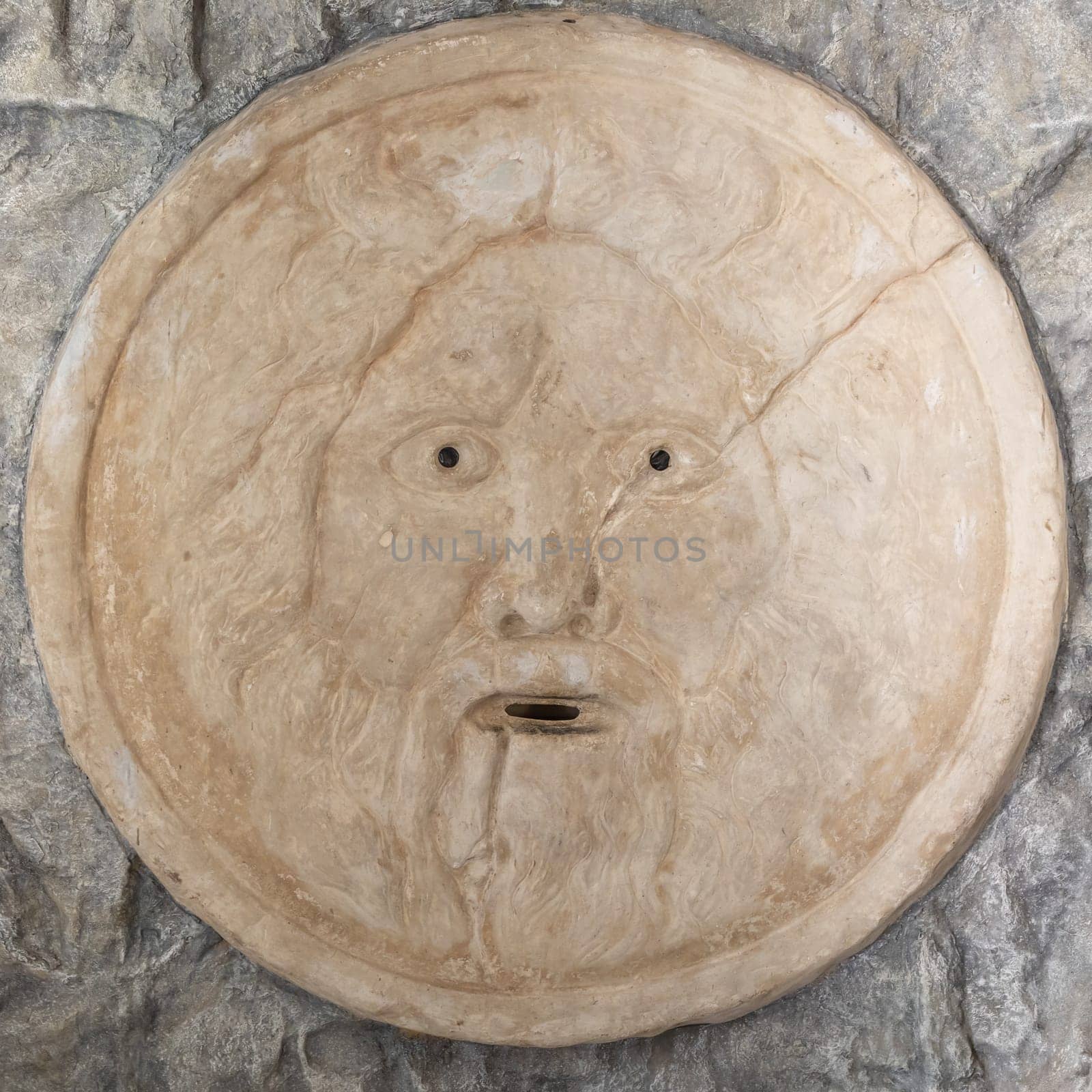 Mouth of truth sightseeing in Rome, Italy. Historical sculpture made of marble with antique face full of mystery and legend.